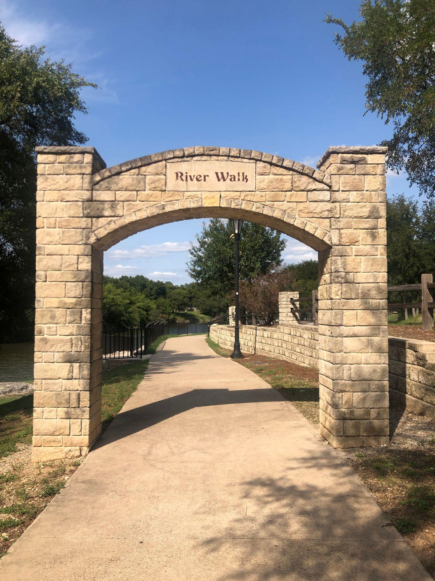 An archway labeled 'riverwalk' over a pathway.