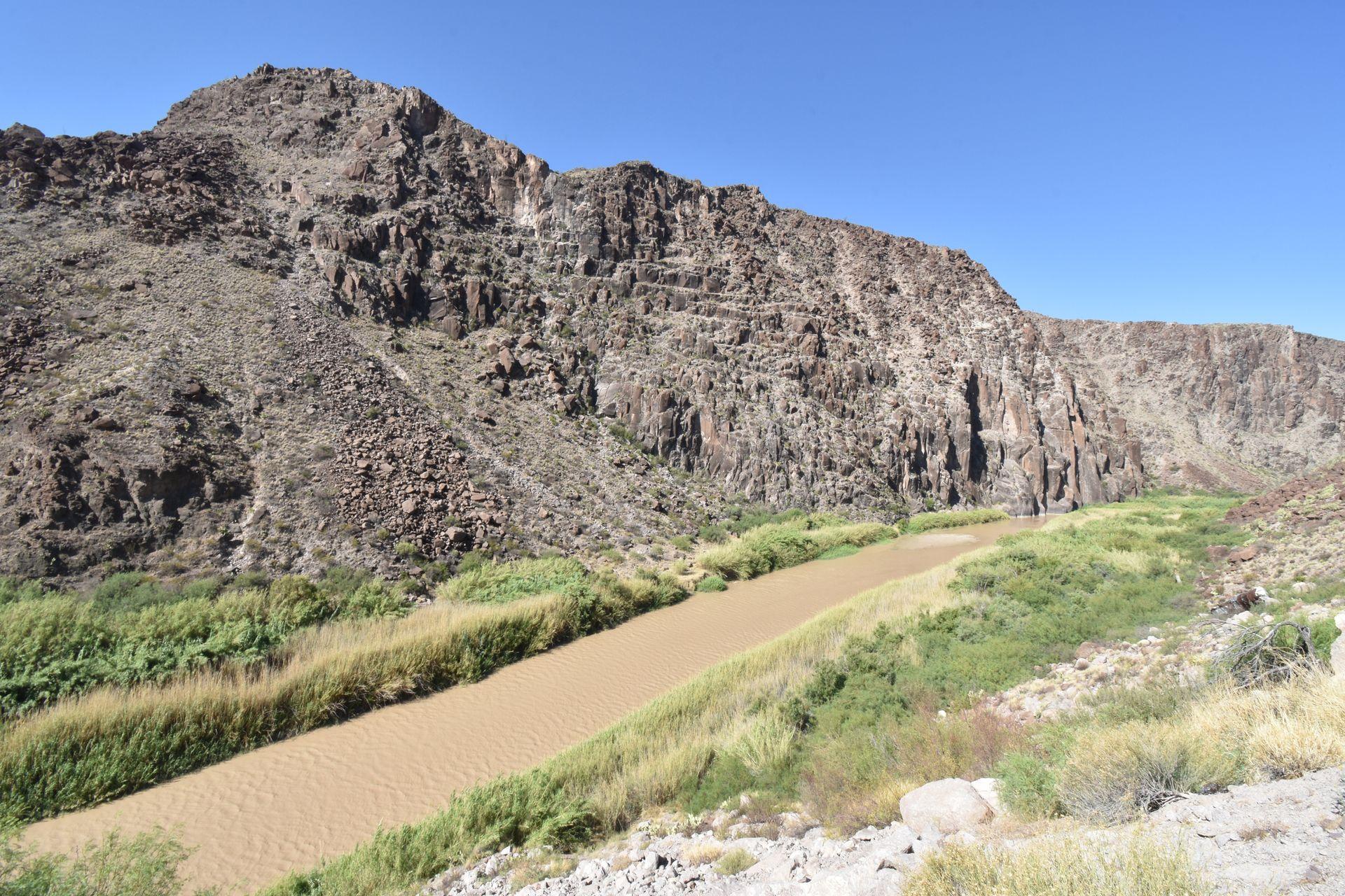 A view of the Rio Grande River with a canyon wall behind it while driving through Big Bend Ranch State Park.