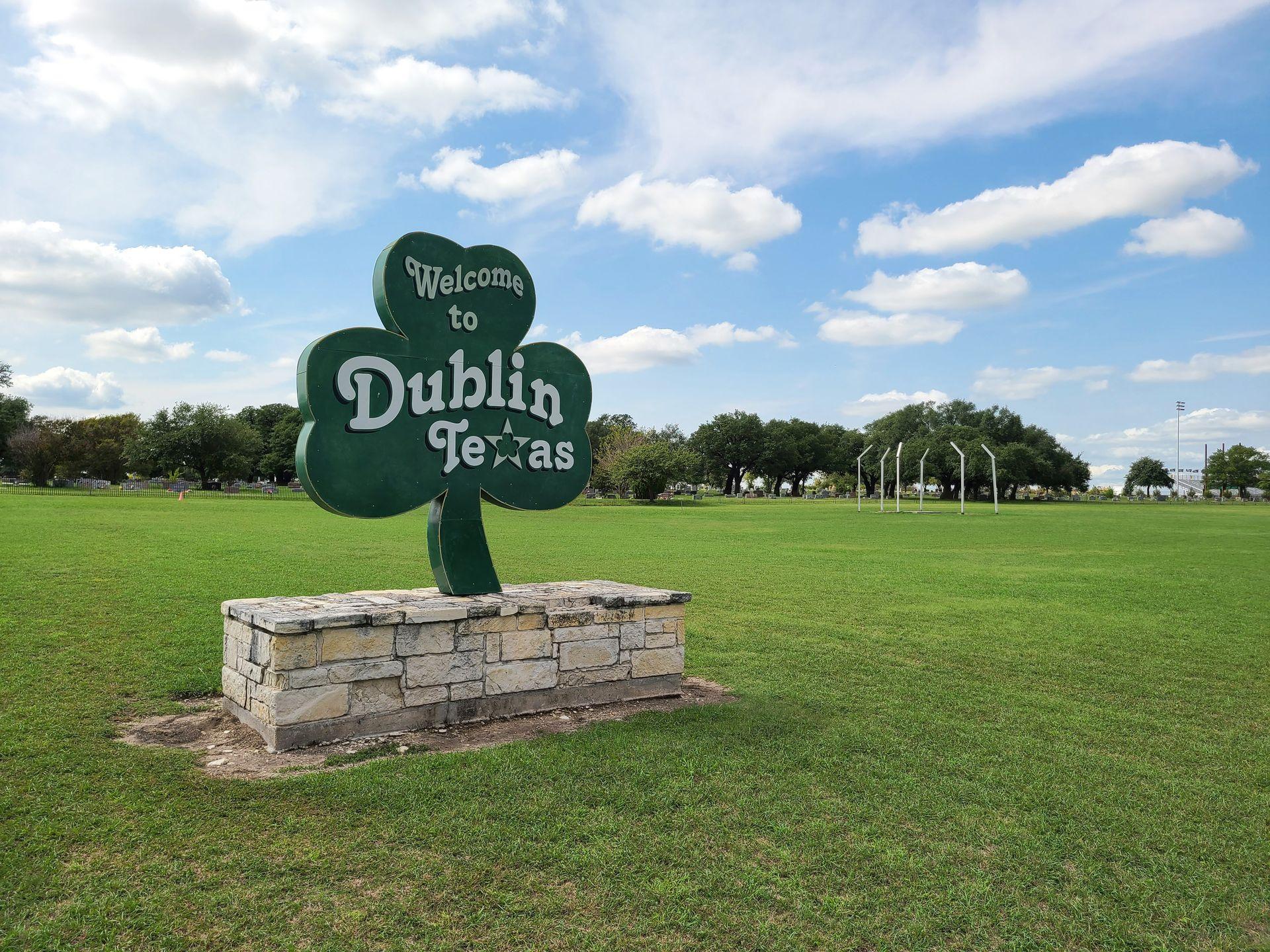 A large, green, four leaf clover sign that reads "Welcome to Dublin, Texas"