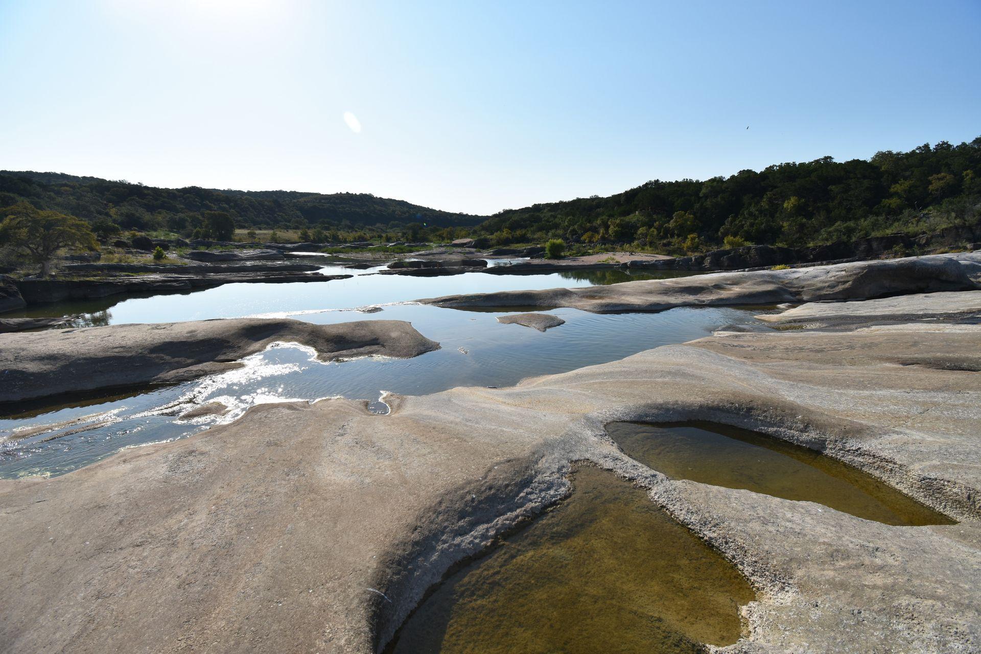 An area of rocks and water at Pedernales Falls. There are several pools of water within the rock faces.