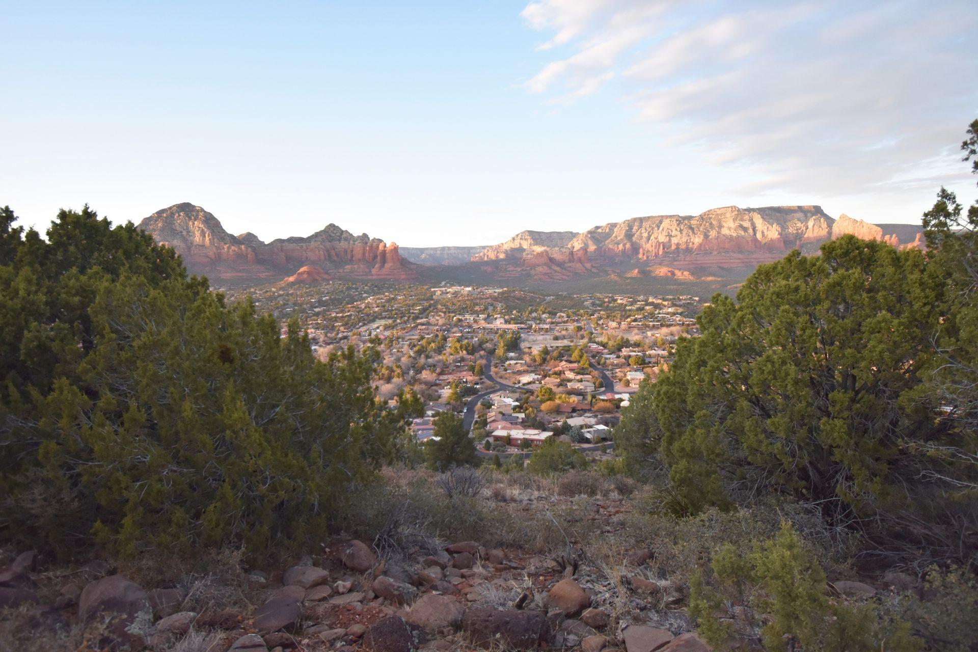 A view looking down at Sedona with mountains in the background.