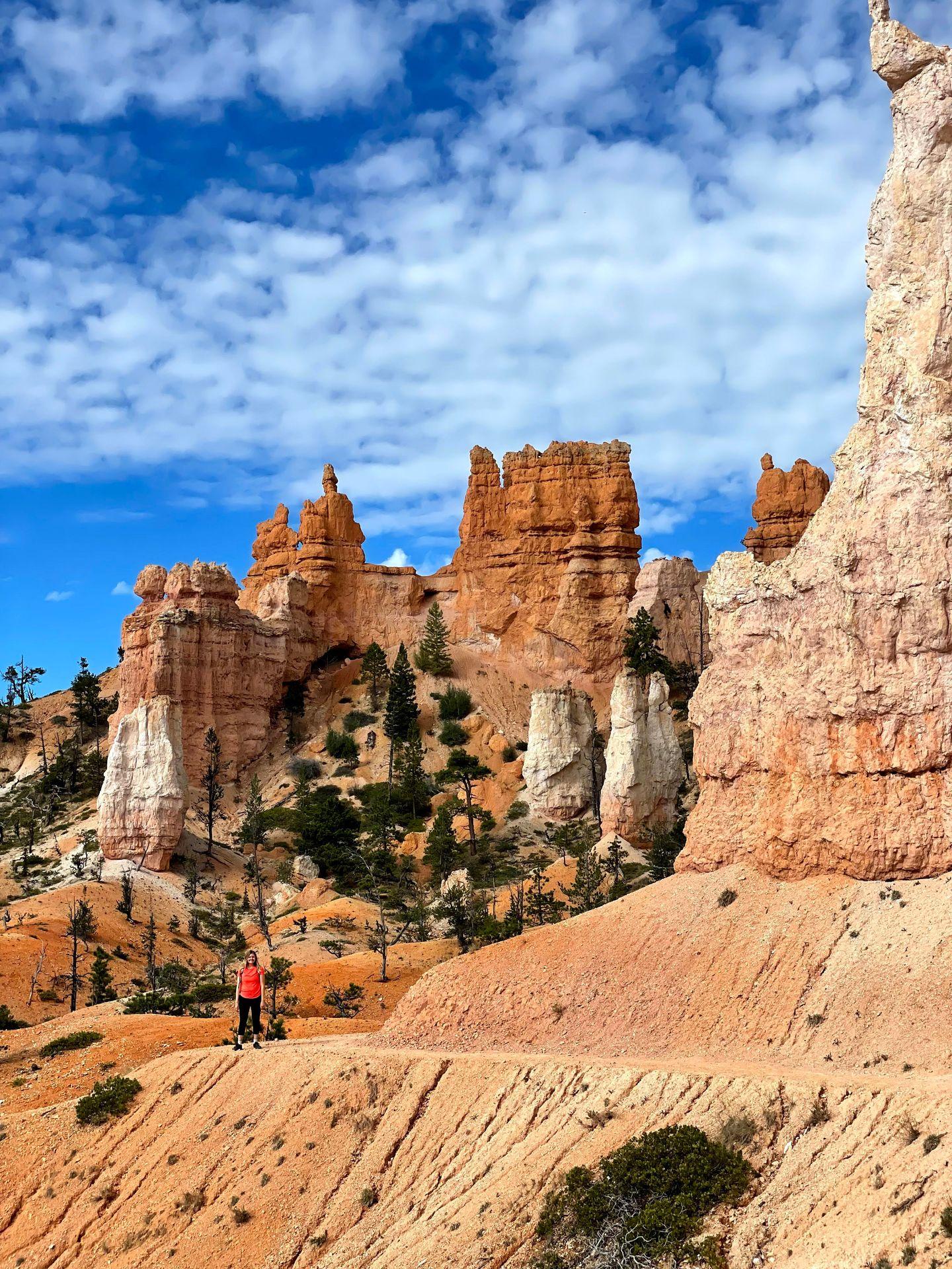 Lydia standing on the Fairyland Loop trail with hoodoo rock formations in the background.