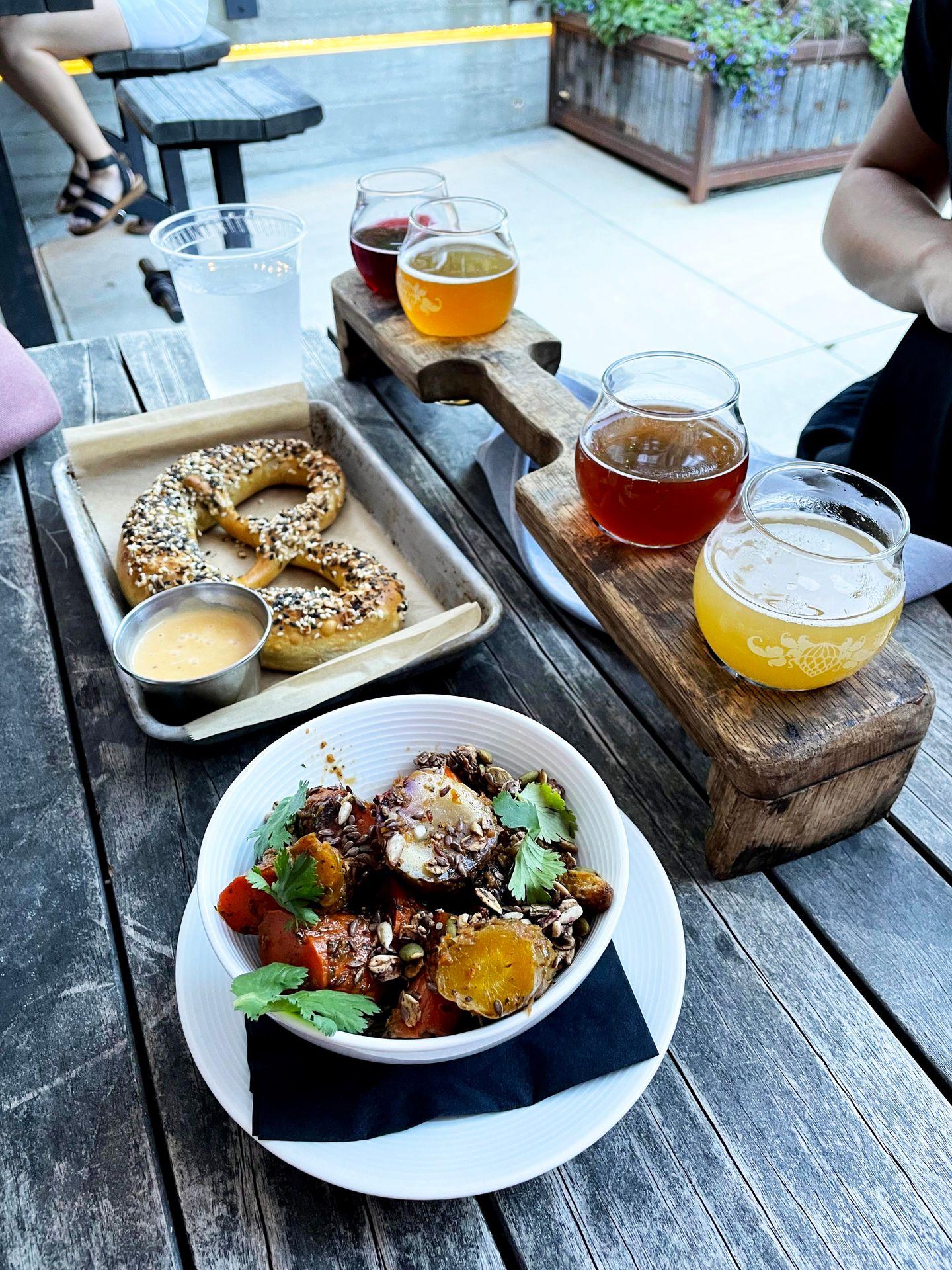 A soft pretzel, a plate of veggies and a flight of beer from Wicked Weed Funkatorium.