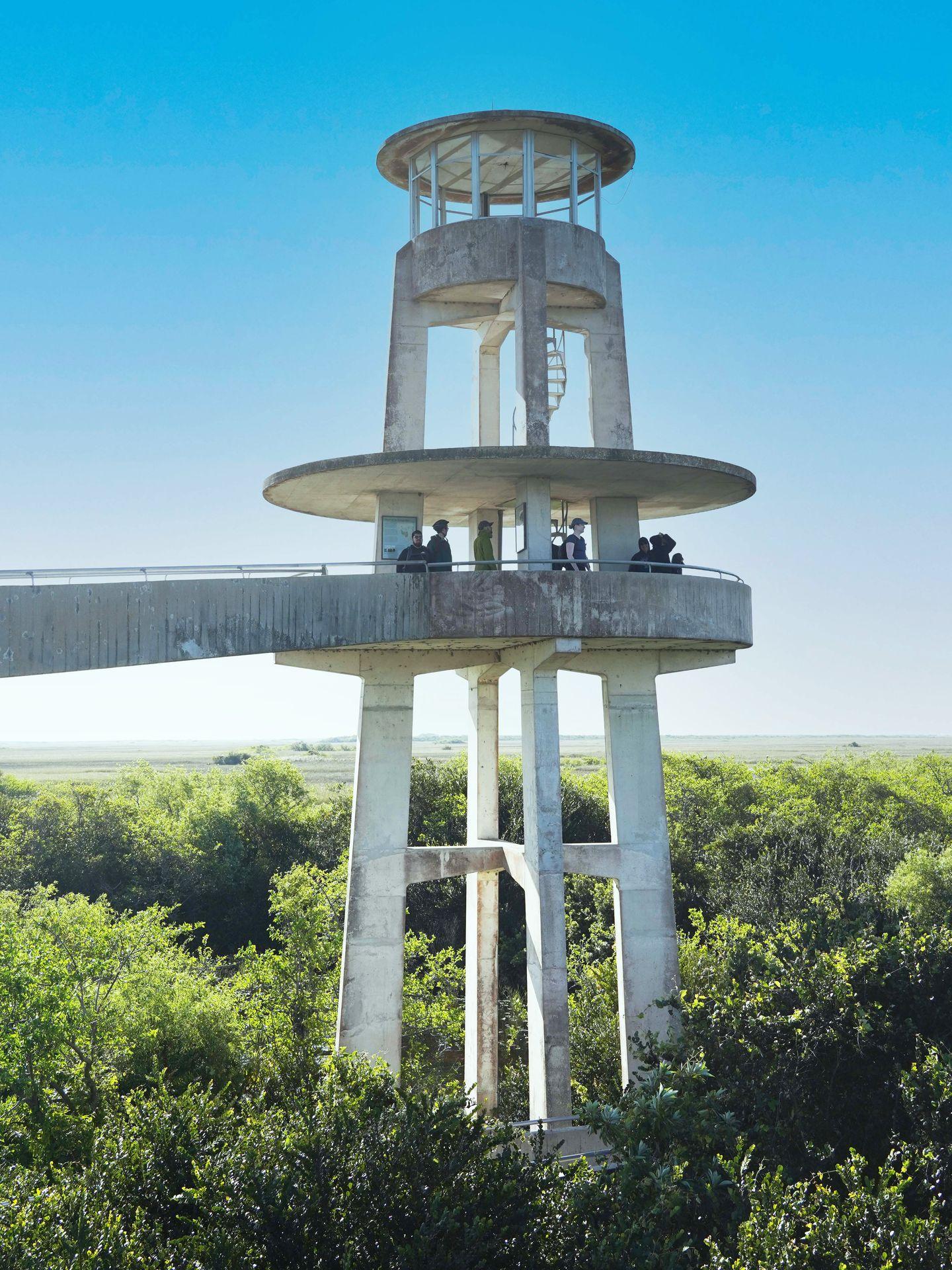A path leading up to a gray observation tower with a spiral staircase in the center.