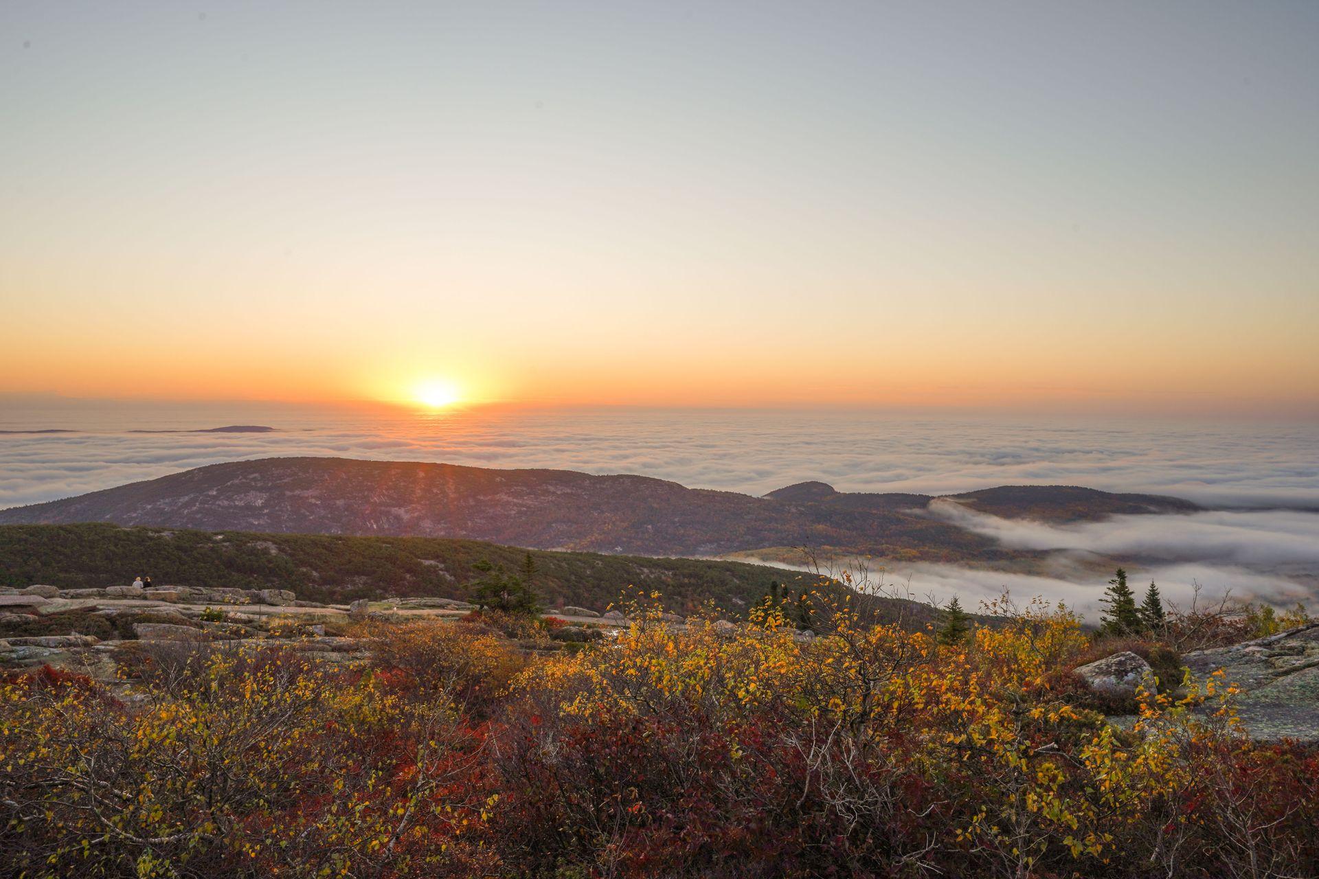 The sun rising over a cloud inversion from Cadillac Mountain