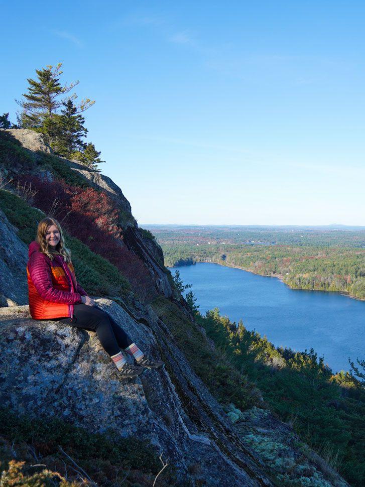 Lydia sitting on the edge of a cliff with Echo Lake in the distance.