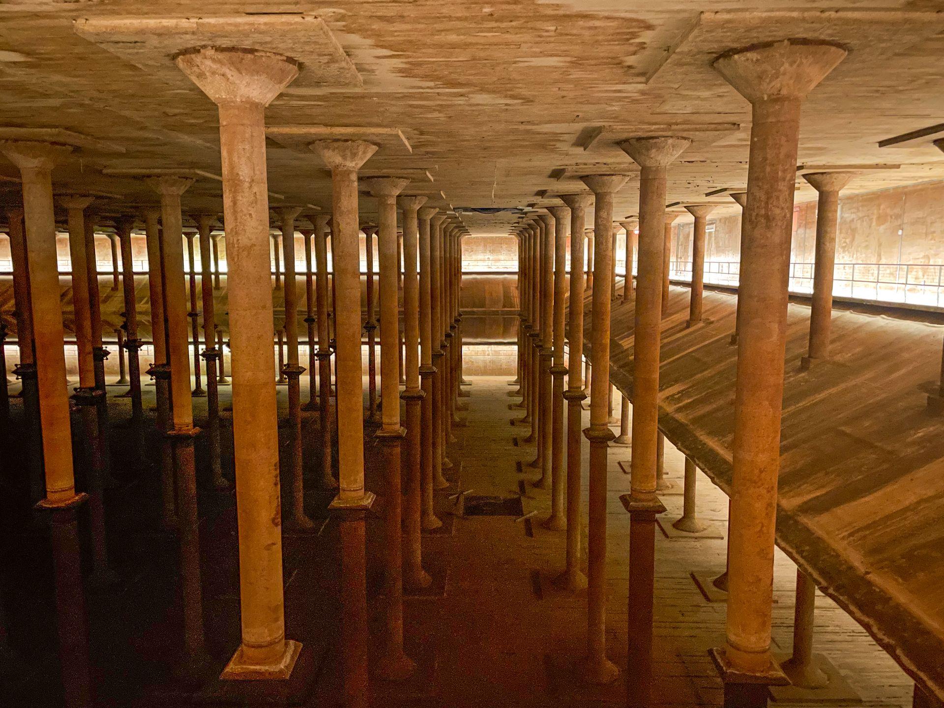 Looking out at part of the Buffalo Bayou Cistern. Columns reflect in the water at the base of the space