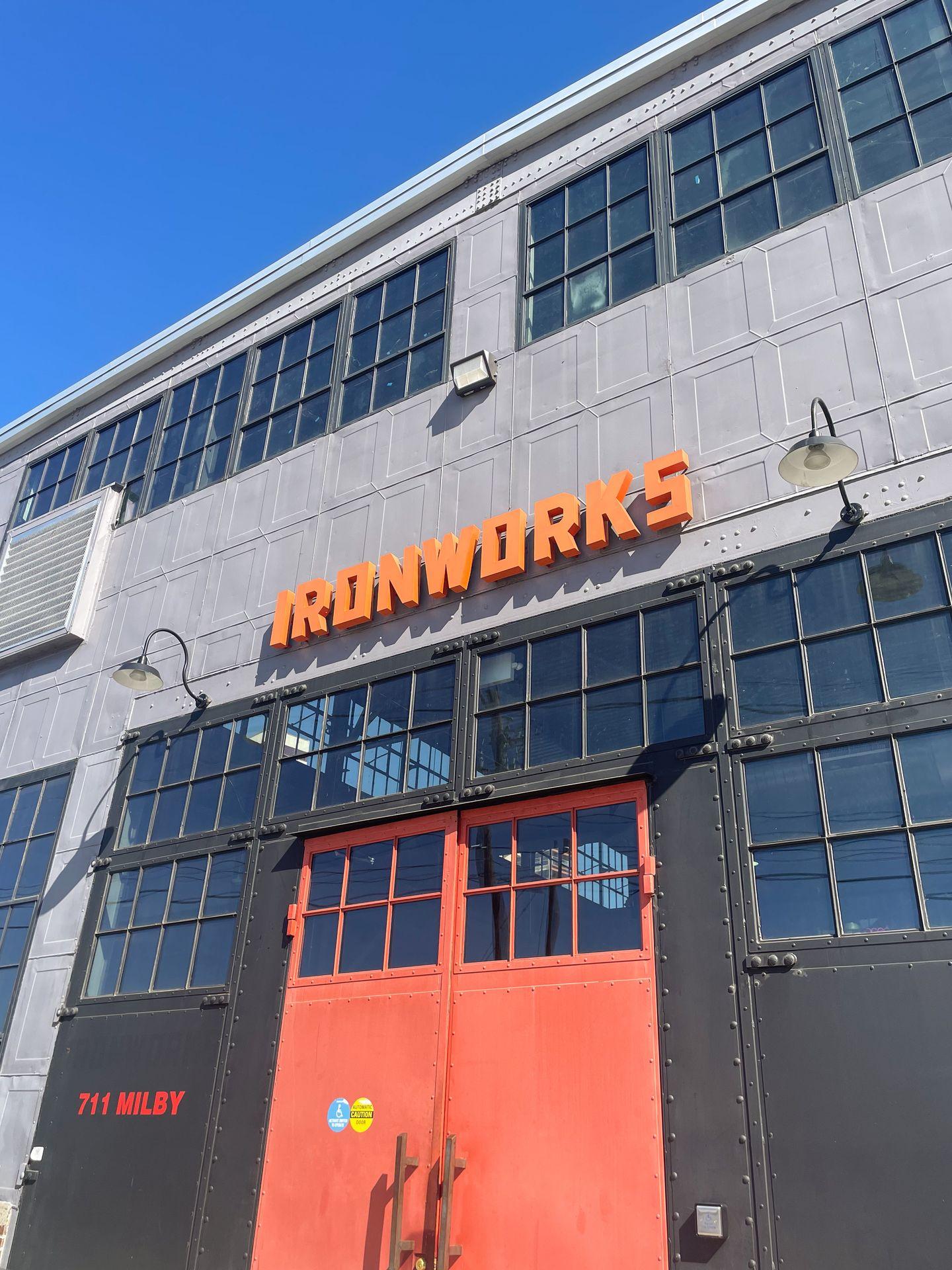 The exterior of the Ironworks building. There are orange doors and it reads 'Ironworks' in orange letters.