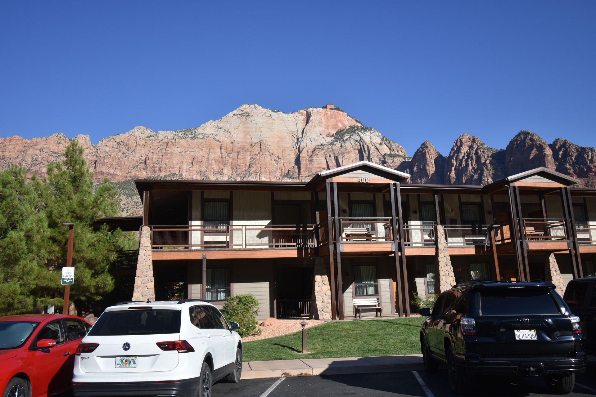 The exterior of La Quinta in Springdale, UT. There are red rock cliffs behind the hotel.