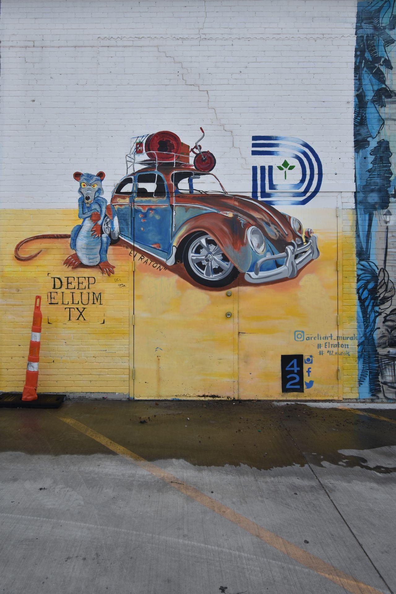 A mural with a vintage Volkswagen beetle, with a giant mouse next to it.