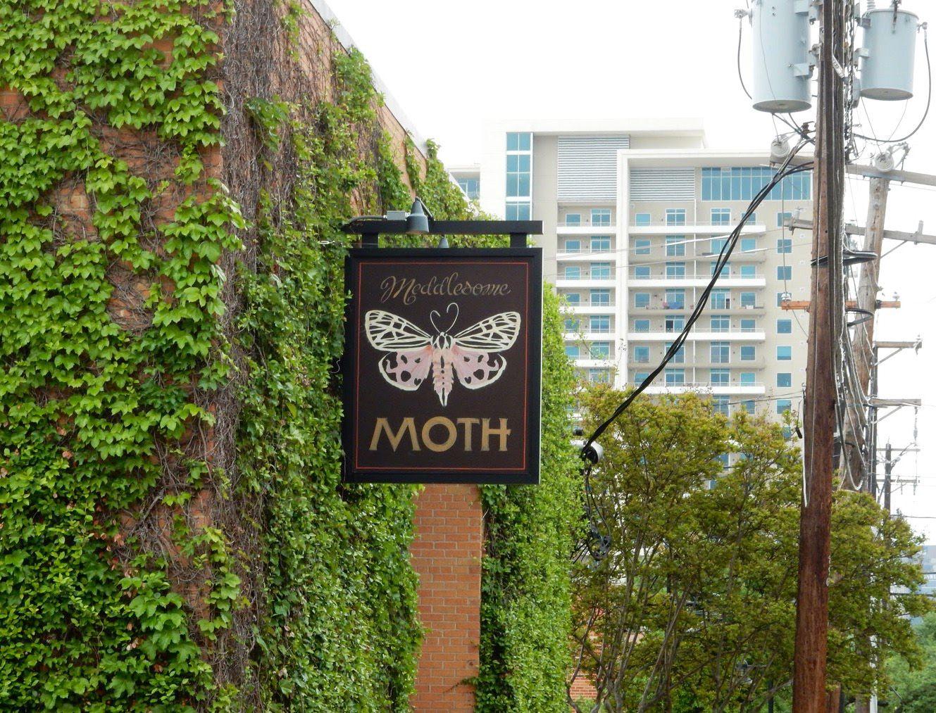 A vine-covered building with a sign for "Meddlesome Moth."
