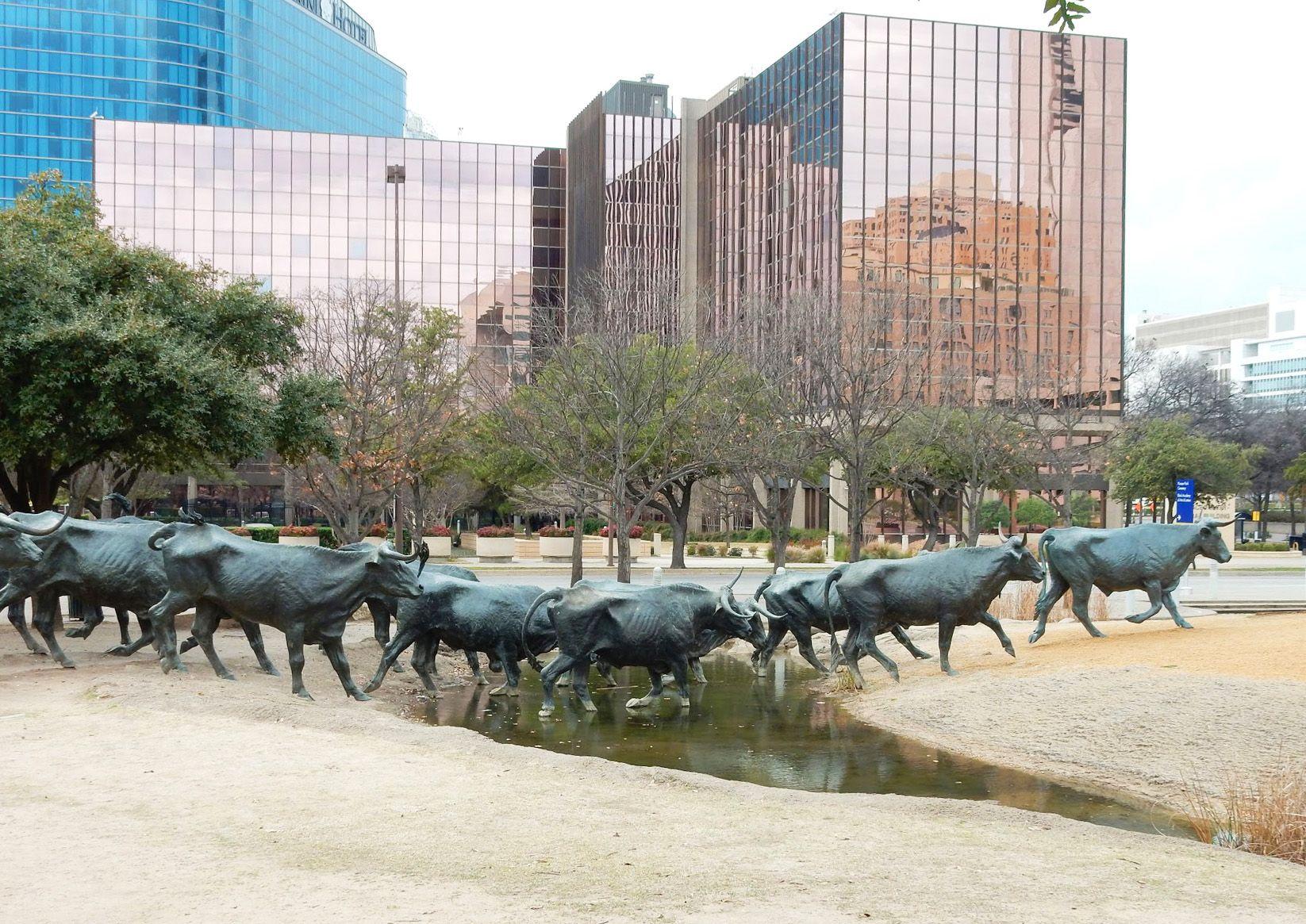 A display of several bronze bulls that look like they are running through a river.