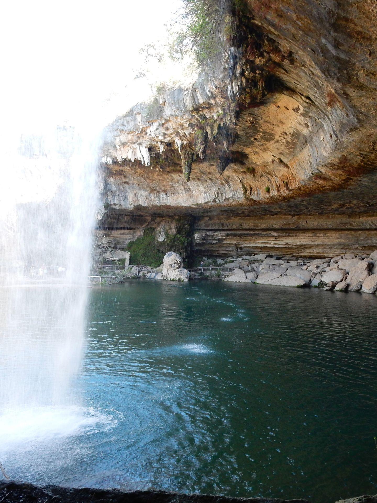 A waterfall coming down from a large overhang at Hamilton Pool Preserve.