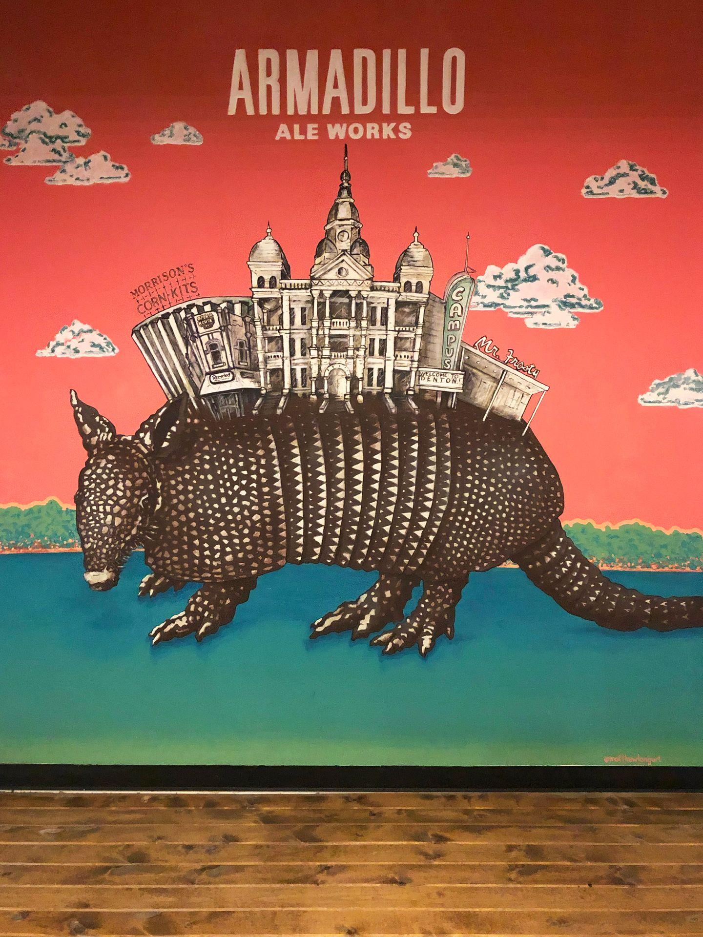 A mural of an Armadillo with the Denton courthouse on its' back inside of Armadillo Ale Works.