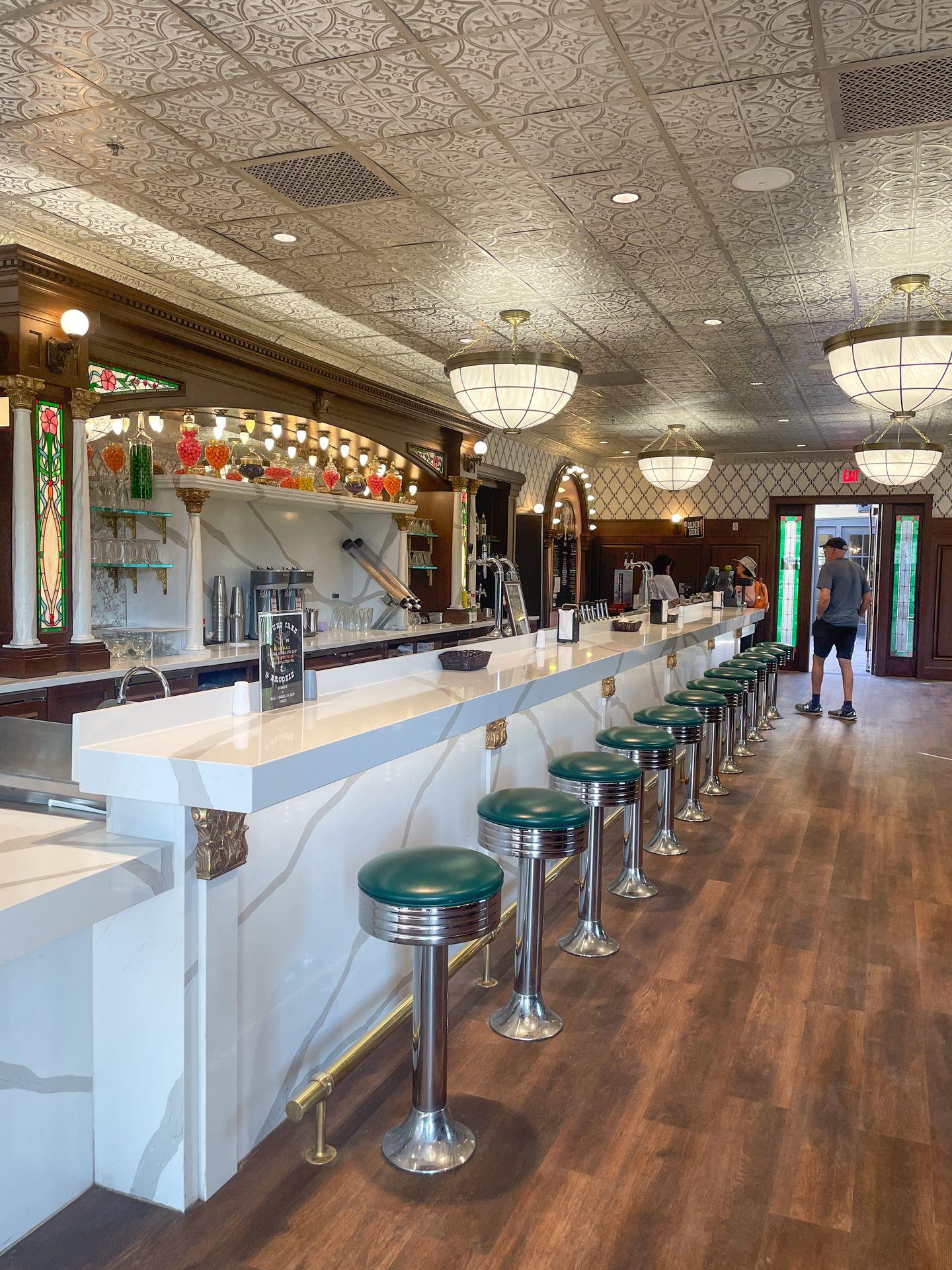 A vintage-looking bar with green bar stools inside the Death Valley Ice Cream Parlor