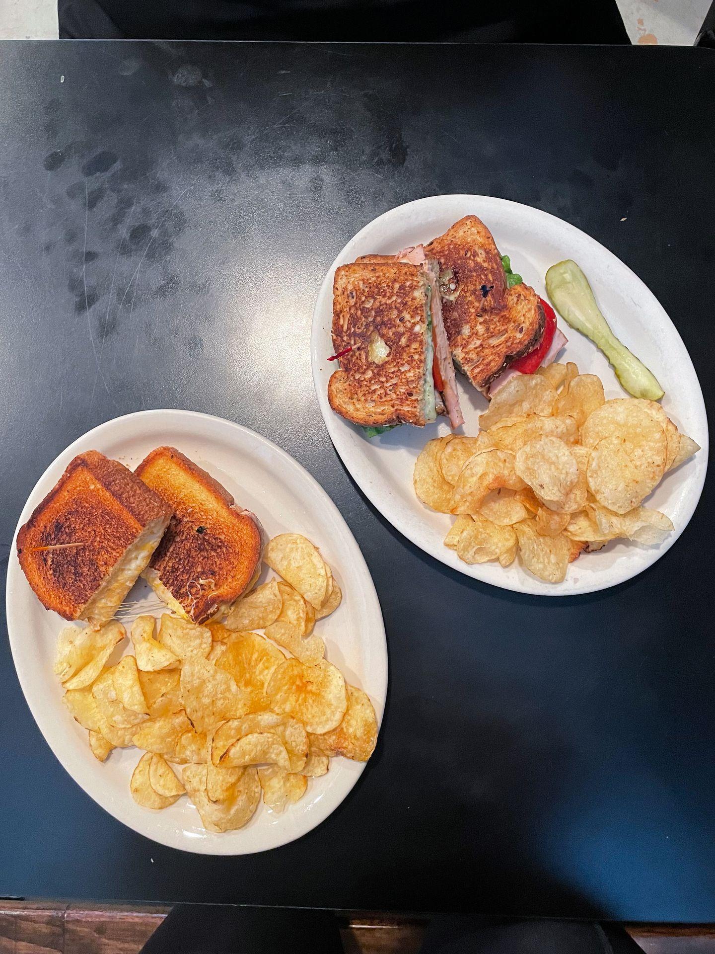 Two plates on sandwiches and chips from Lucy's Cafe