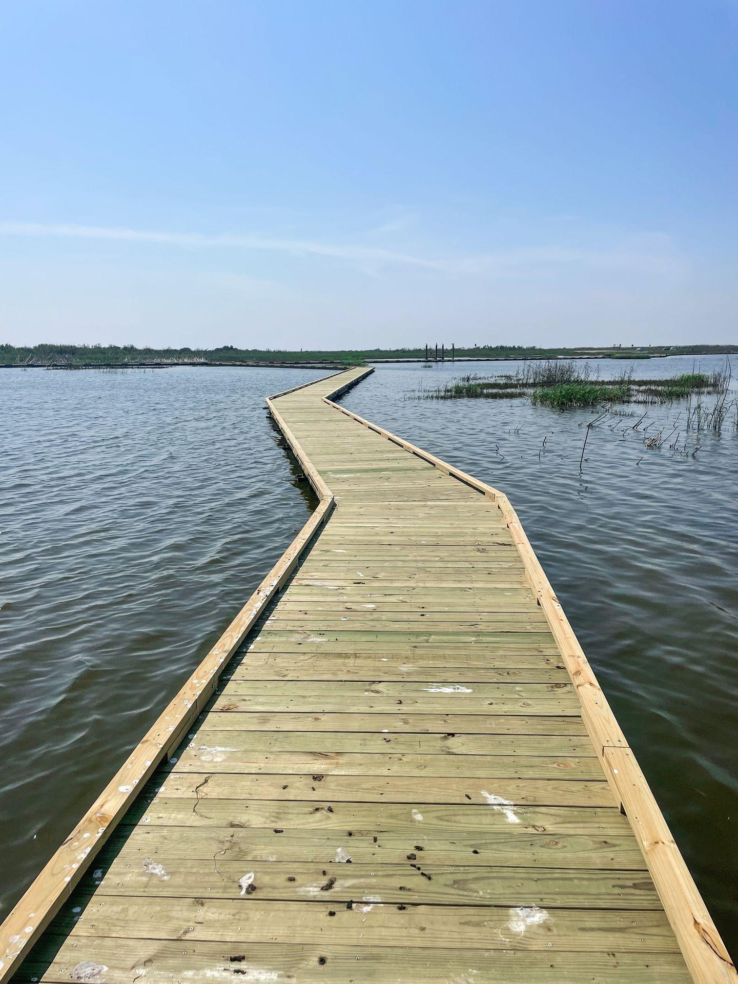 A boardwalk trail surrounded by water at Sea Rim State Park