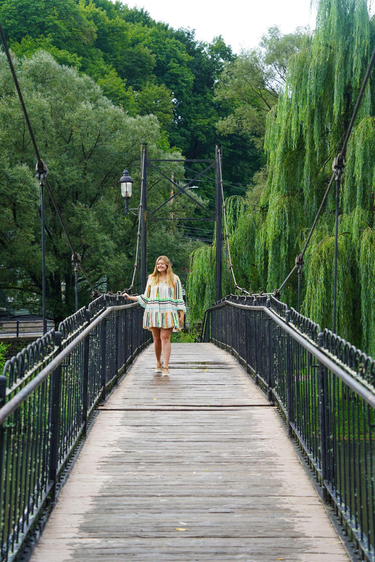 Lydia crossing a bridge in Talleyrand Park. There are trees with hanging moss in the background.