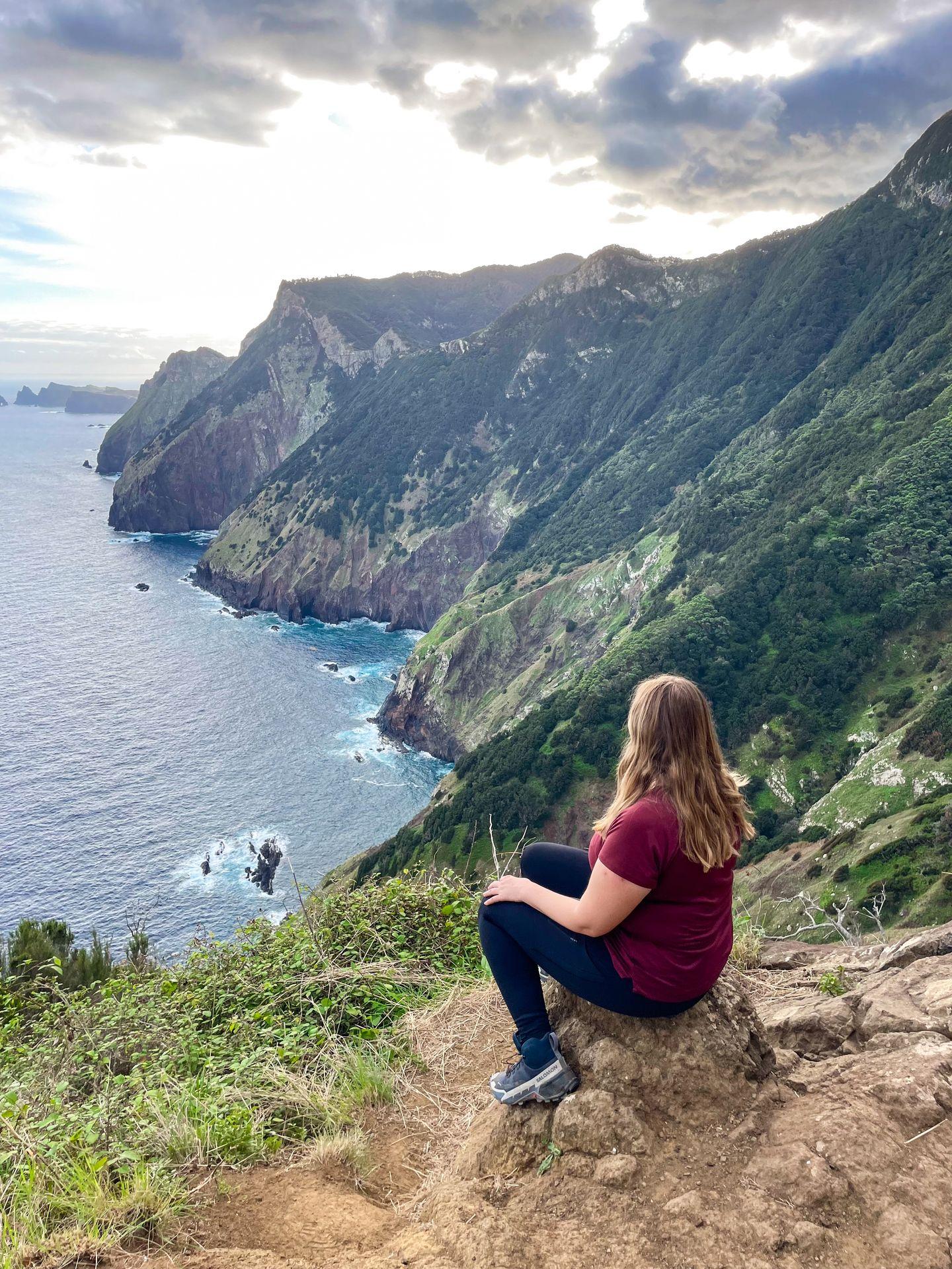 Lydia sitting and looking at the view of the water and coast from the Boca do Risco Trail