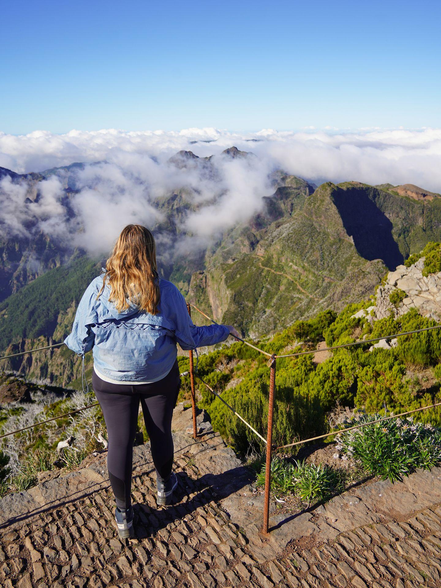 Lydia looking at the view of mountains and clouds from the top of Pico Ruivo