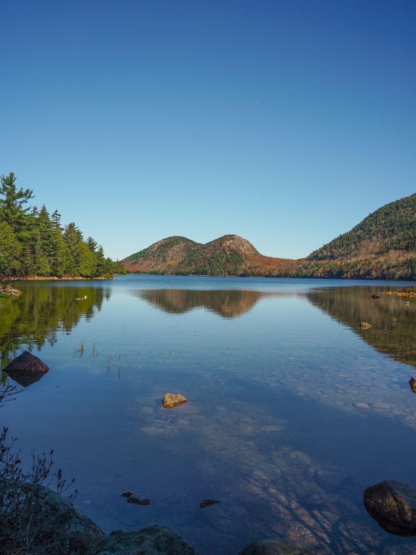 A view of the Bubbles, two mountains that look rounded like bubbles, from across a lake.