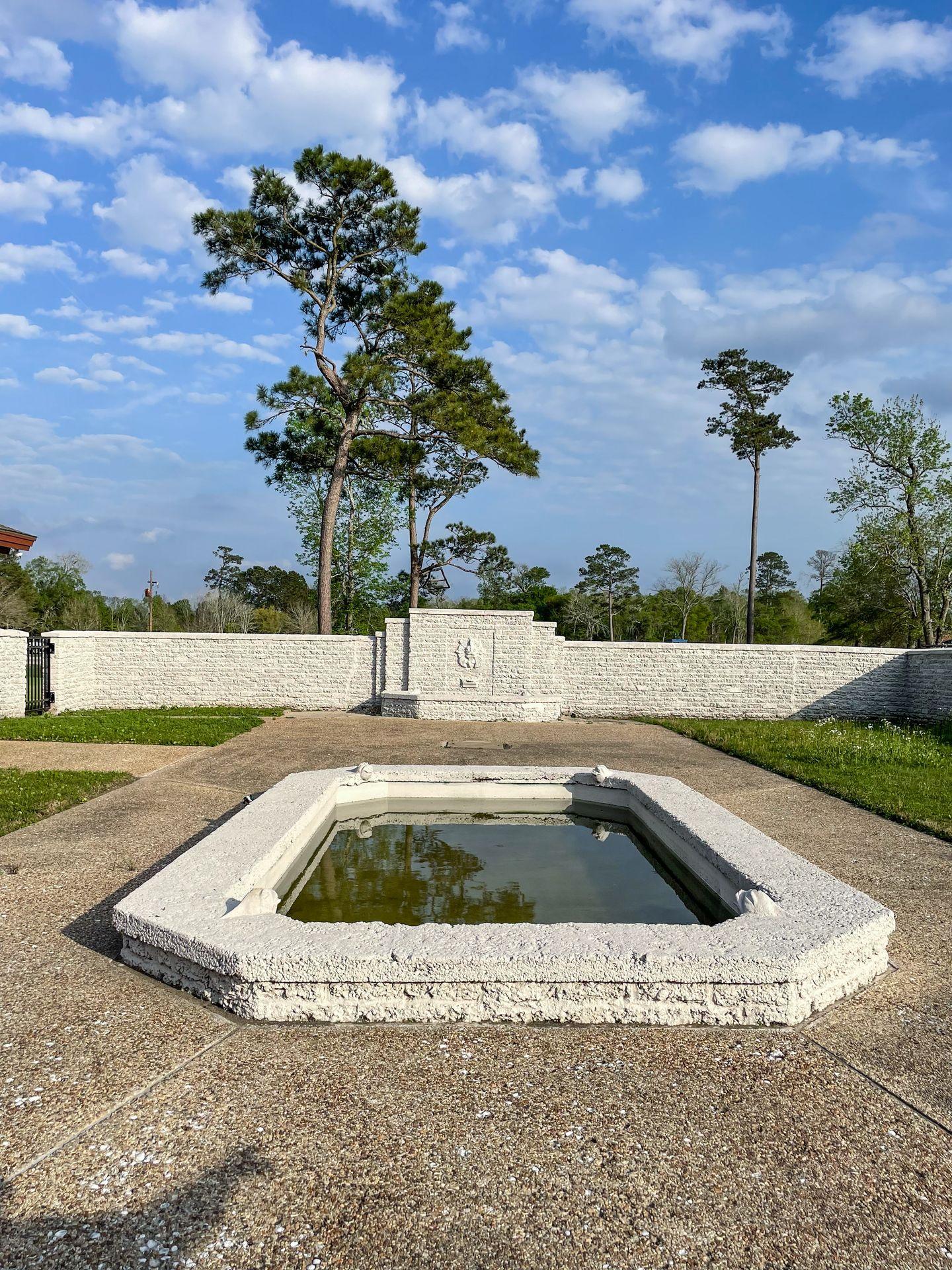 A courtyard area with a pool of water in the center at the Nature Center in Tyrell Park.