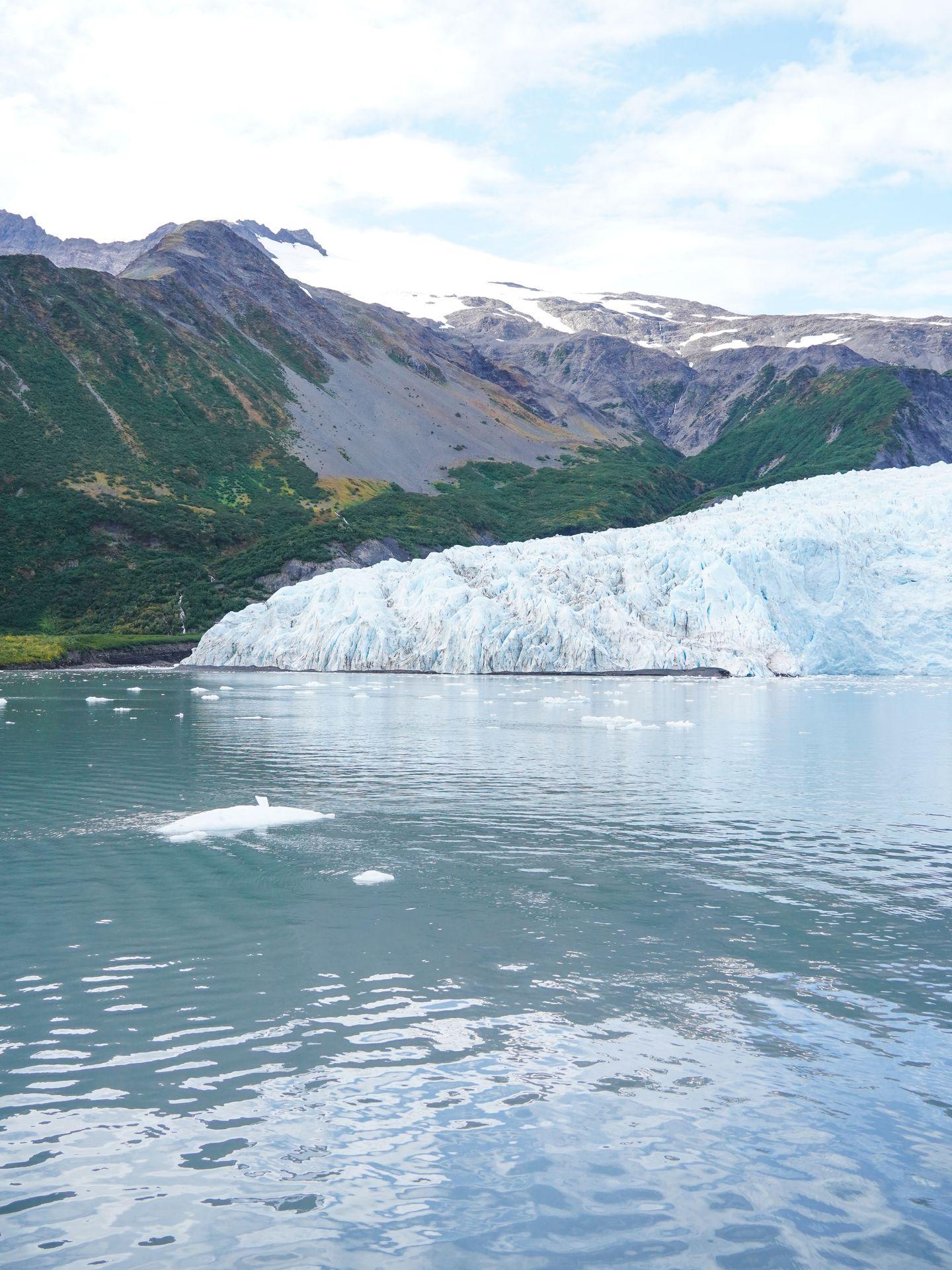 A glacier next to a mountain covered in a bit of snow in Kenai Fjords National Park