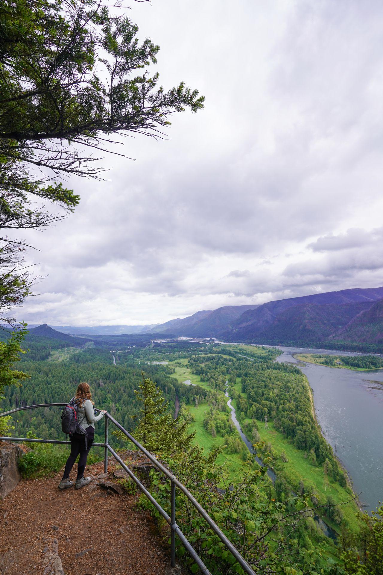 Lydia looking down at a view of the Columbia River from Beacon Rock