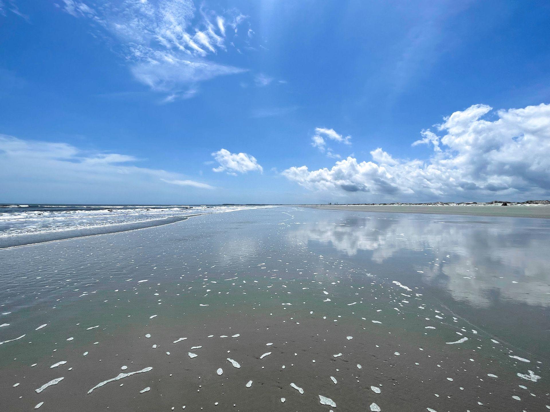 A white sand beach, and water reflecting the sky, on the coast of Cumberland Island