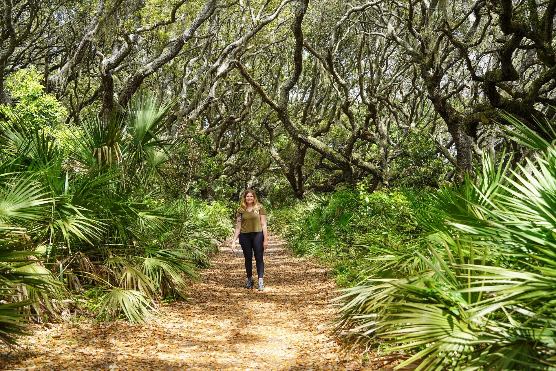 Lydia hiking on a path surrounded by palmetto trees on Cumberland Island