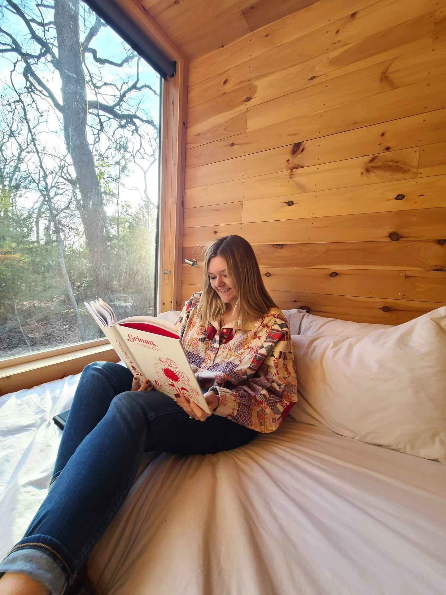 Lydia reading on the bed of the Getaway House.