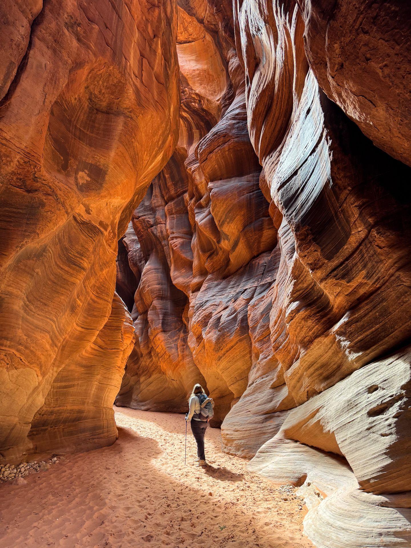 Lydia standing in Buckskin Gulch, with the sun providing nice lighting on the walls of the slot canyon.