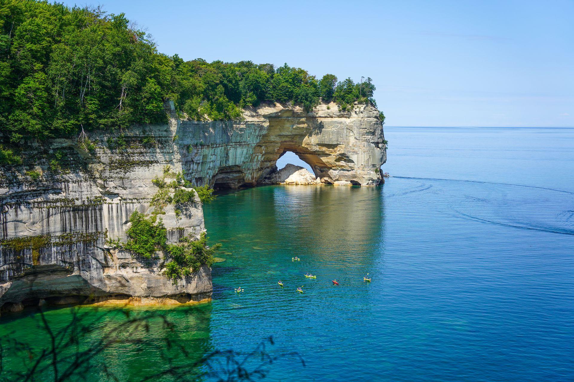 A view of Lover's Leap Arch seen from the trail. There are kayaks in the water below.