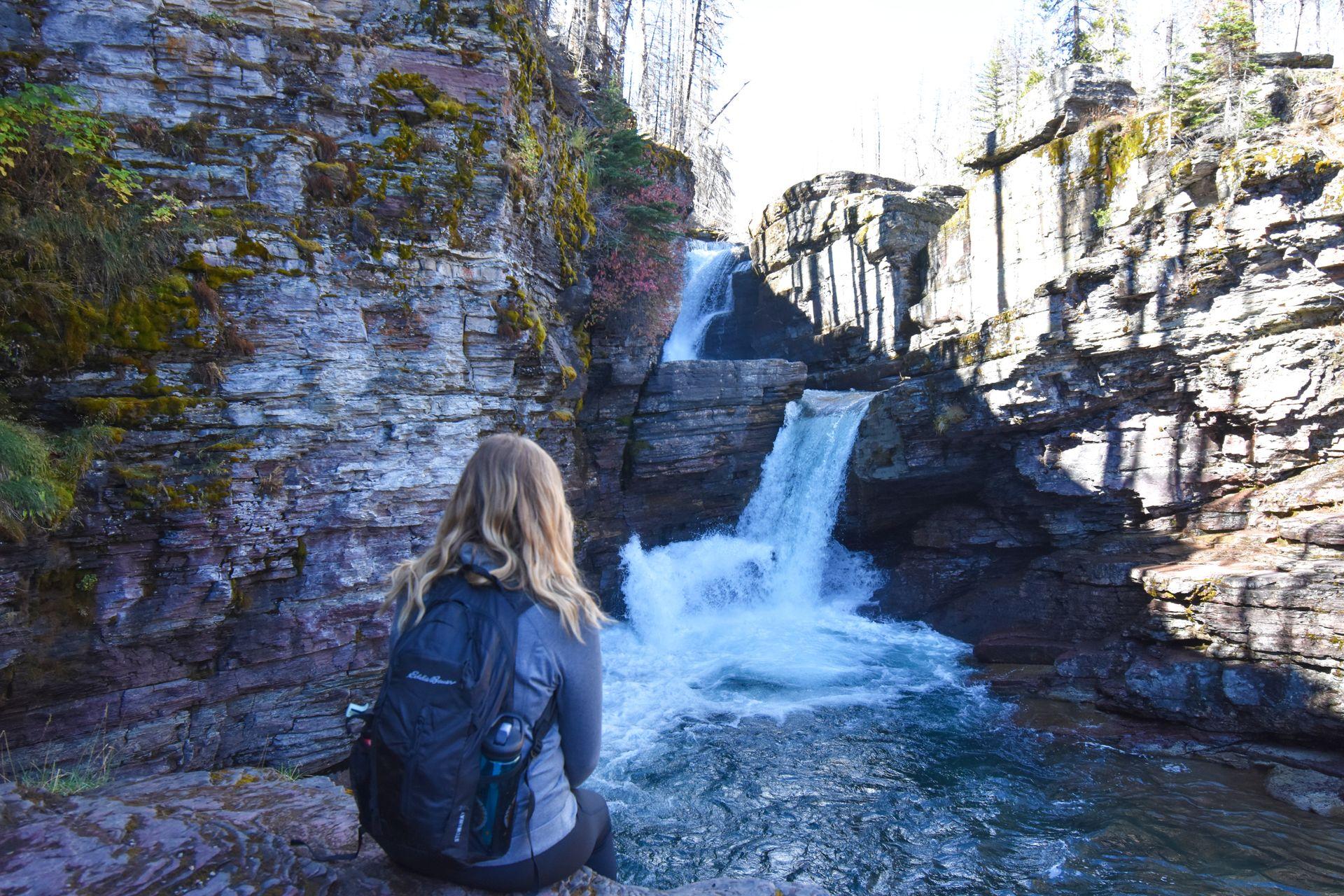Lydia sitting in front of St Mary Falls.