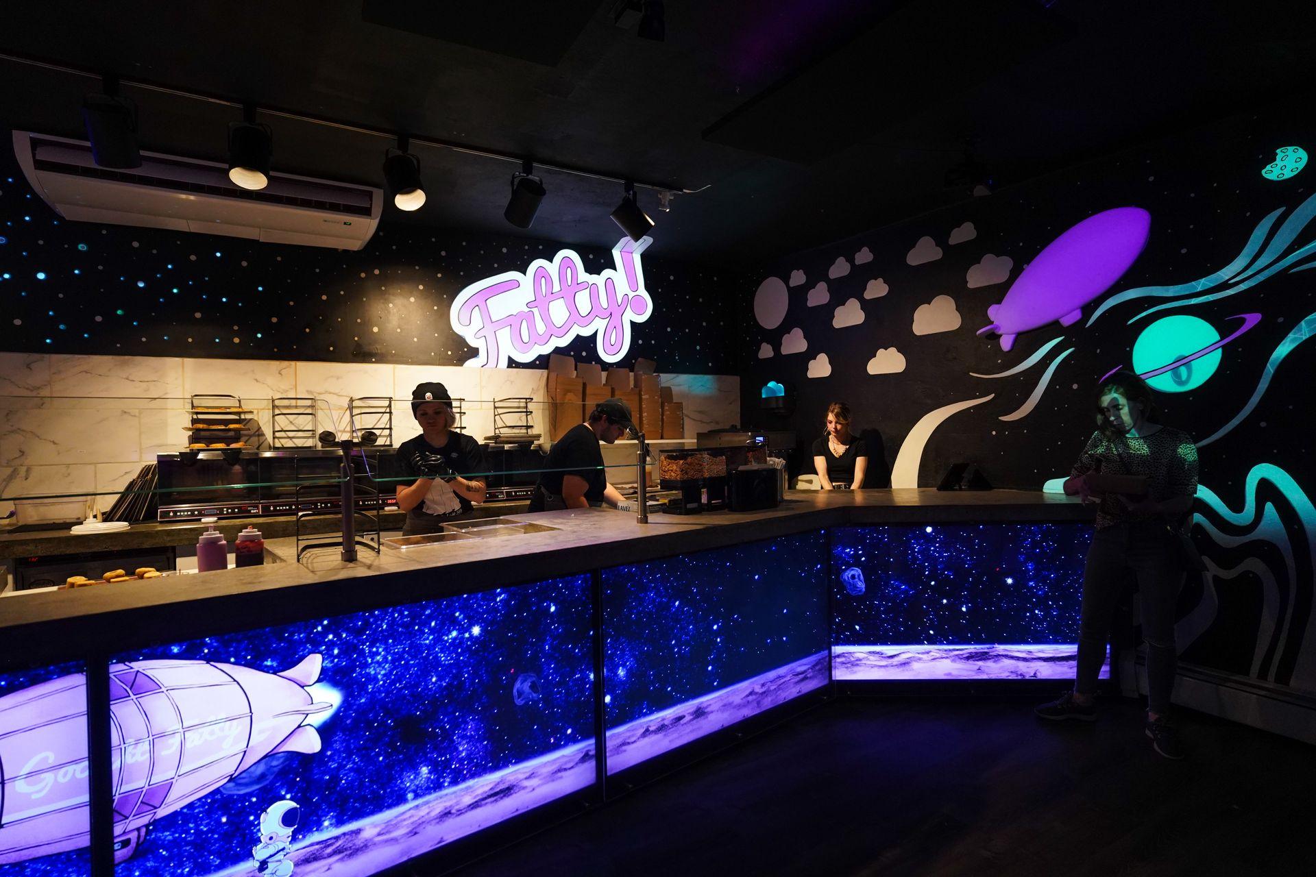 Inside of Goodnight Fatty, a black interior with black light patterns that represent space