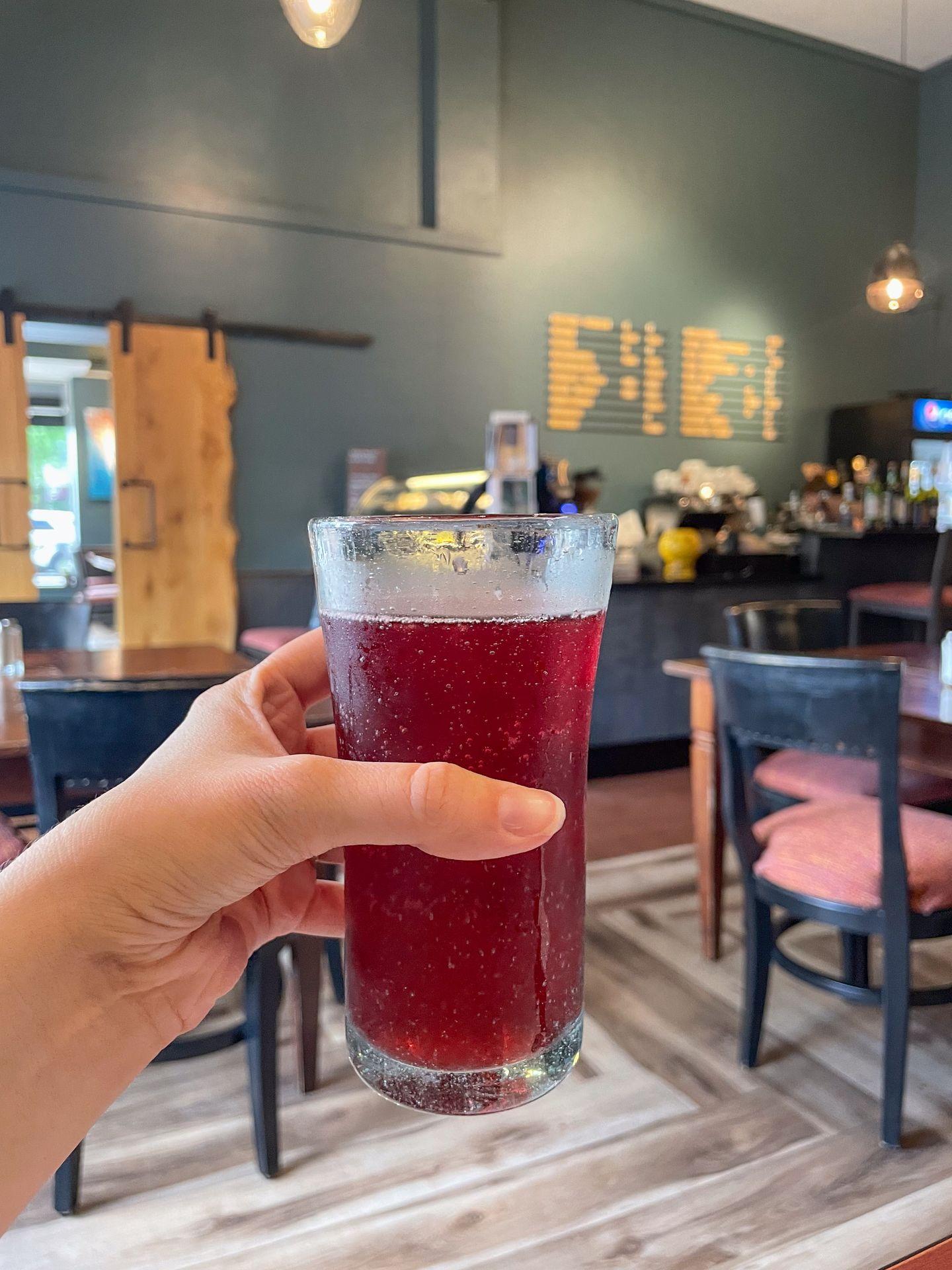 Holding up a red-colored beer at Jules Bistro
