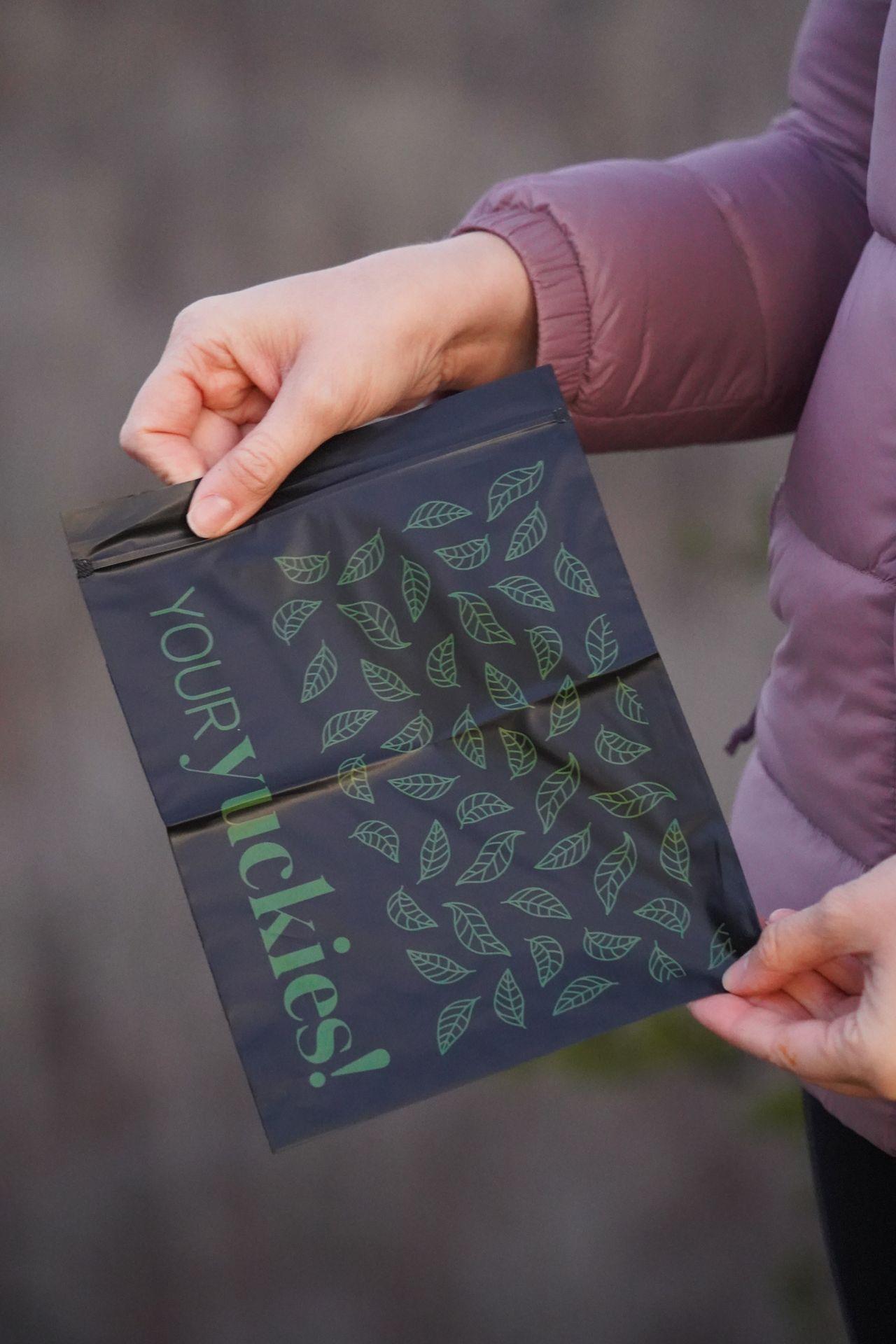 Holding up a Your Yuckie's bag.