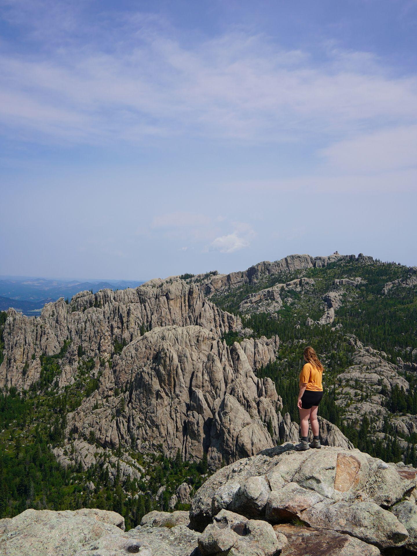 Lydia looking out a view of rock formations while hiking in Custer State Park