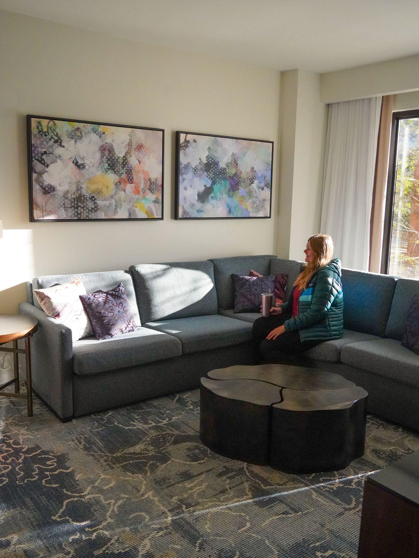 Lydia sitting on the couch inside a hotel room in The Woodlands Resort