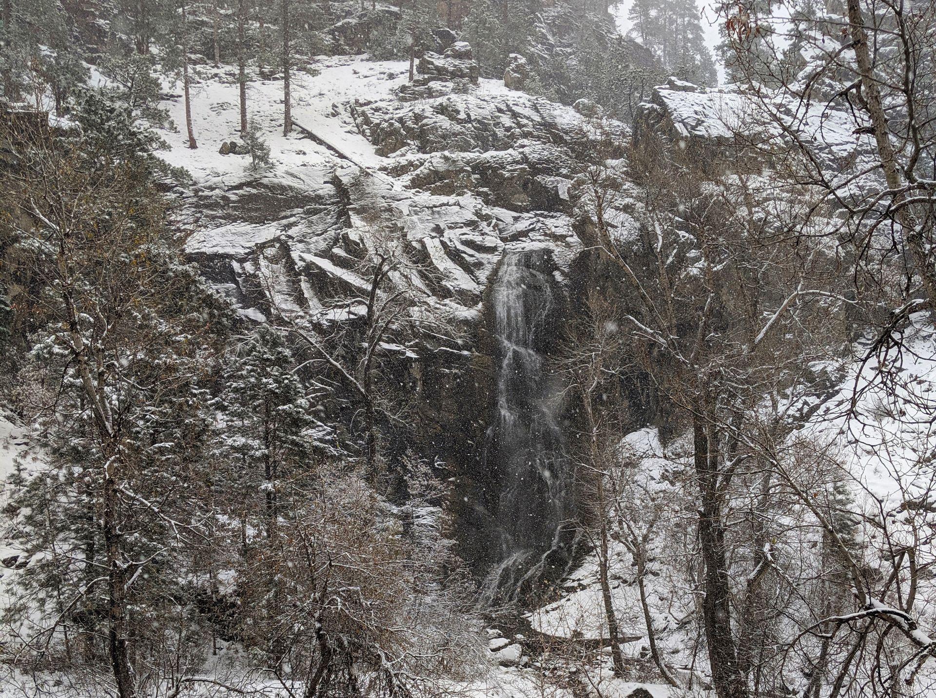 A small waterfall surrounded by snow.