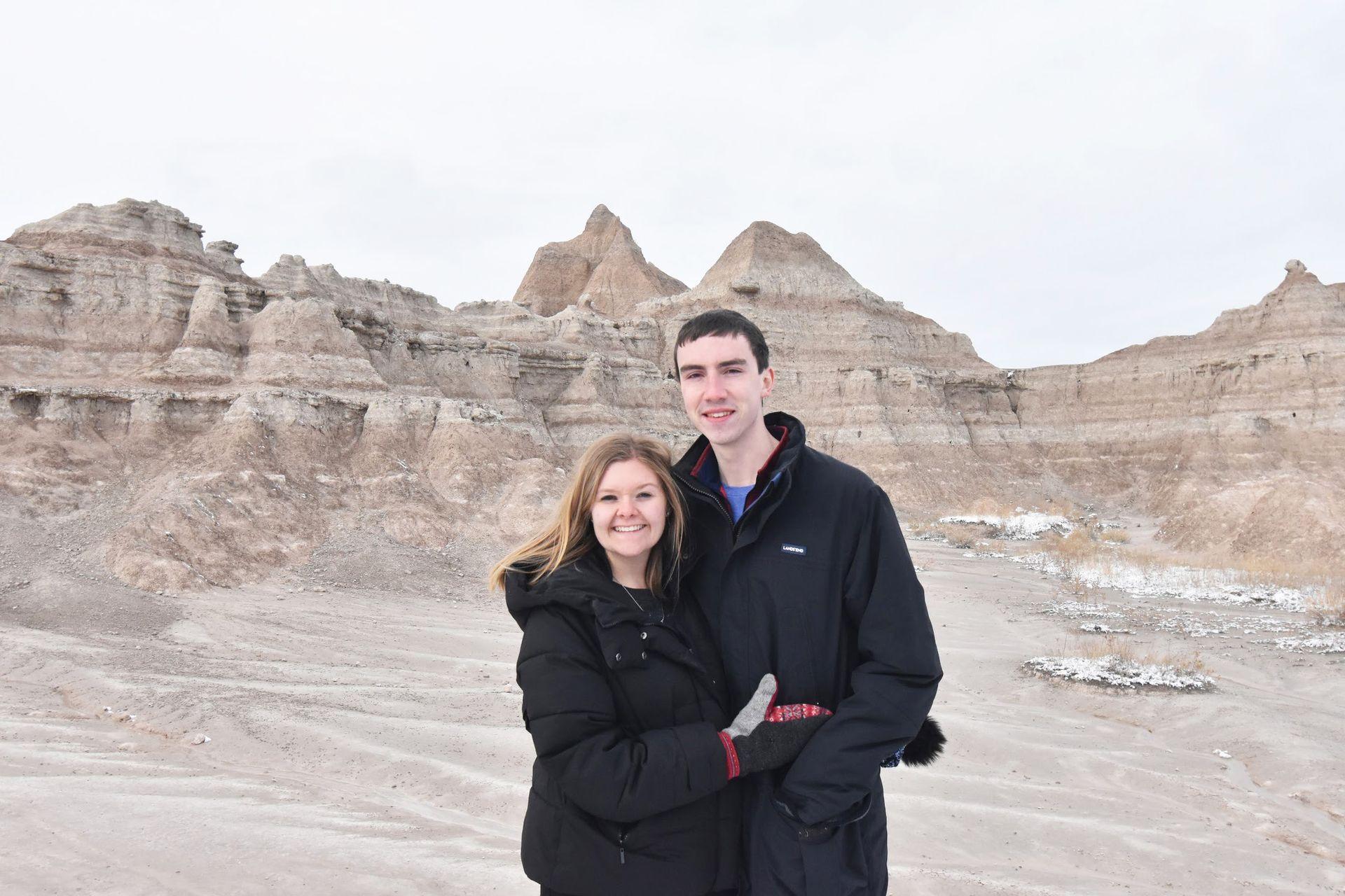 Lydia and Joe standing in front of rocks in the Badlands.