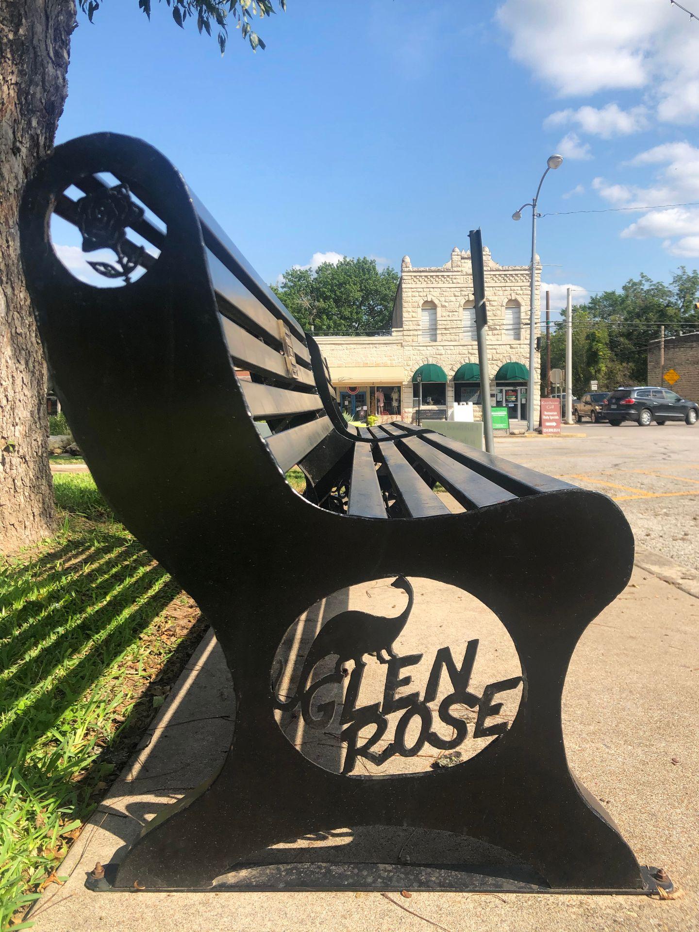 A bench in Glen Rose with a dinosaur design on the side.