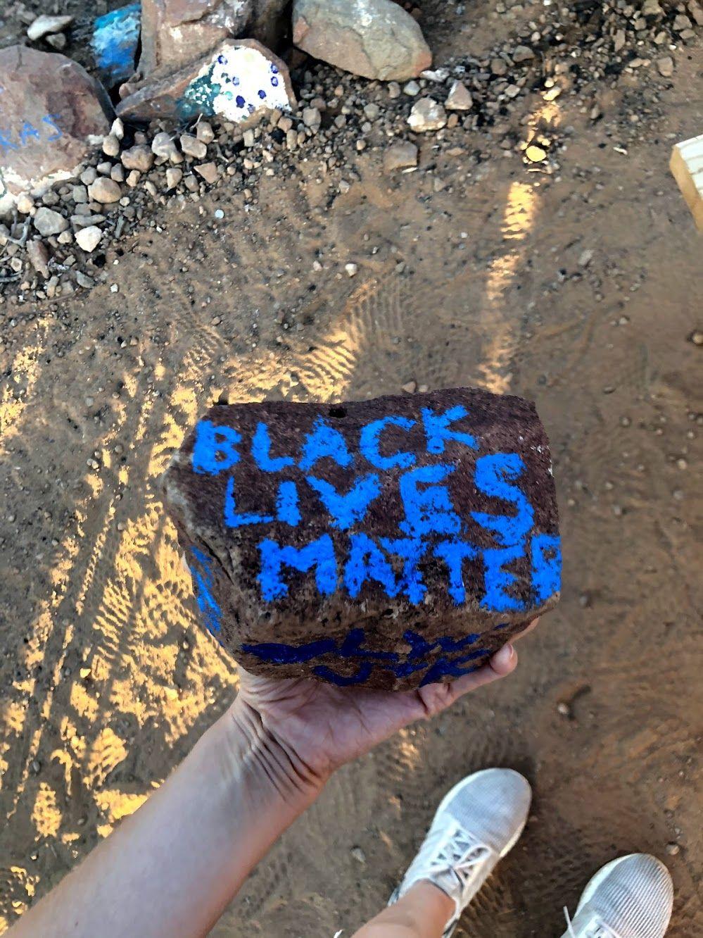 A rock with the words "Black Lives Matter" painted in blue.