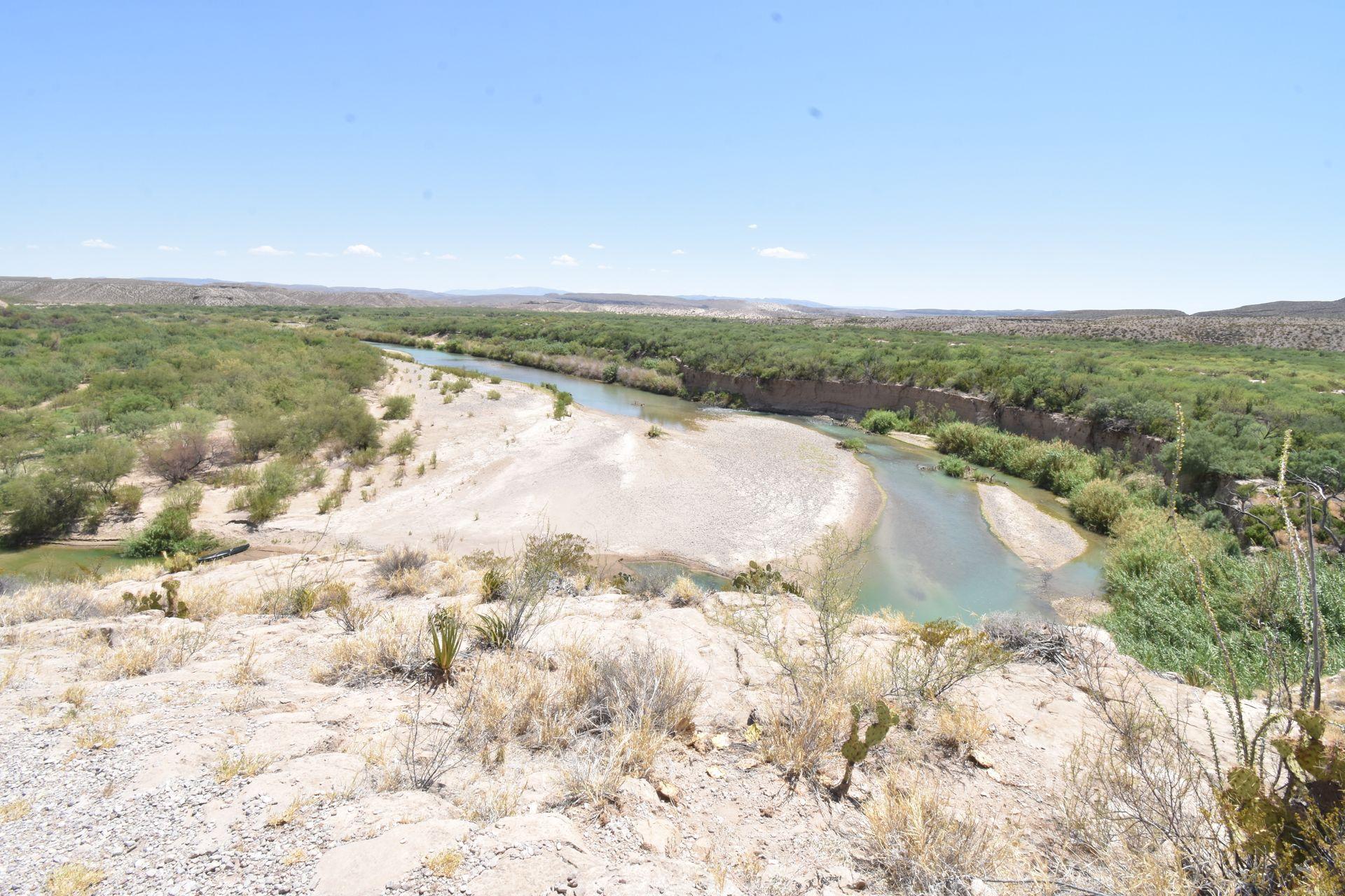 Looking down at the Rio Grande River next to a sandy beach. The beach is in Mexico.