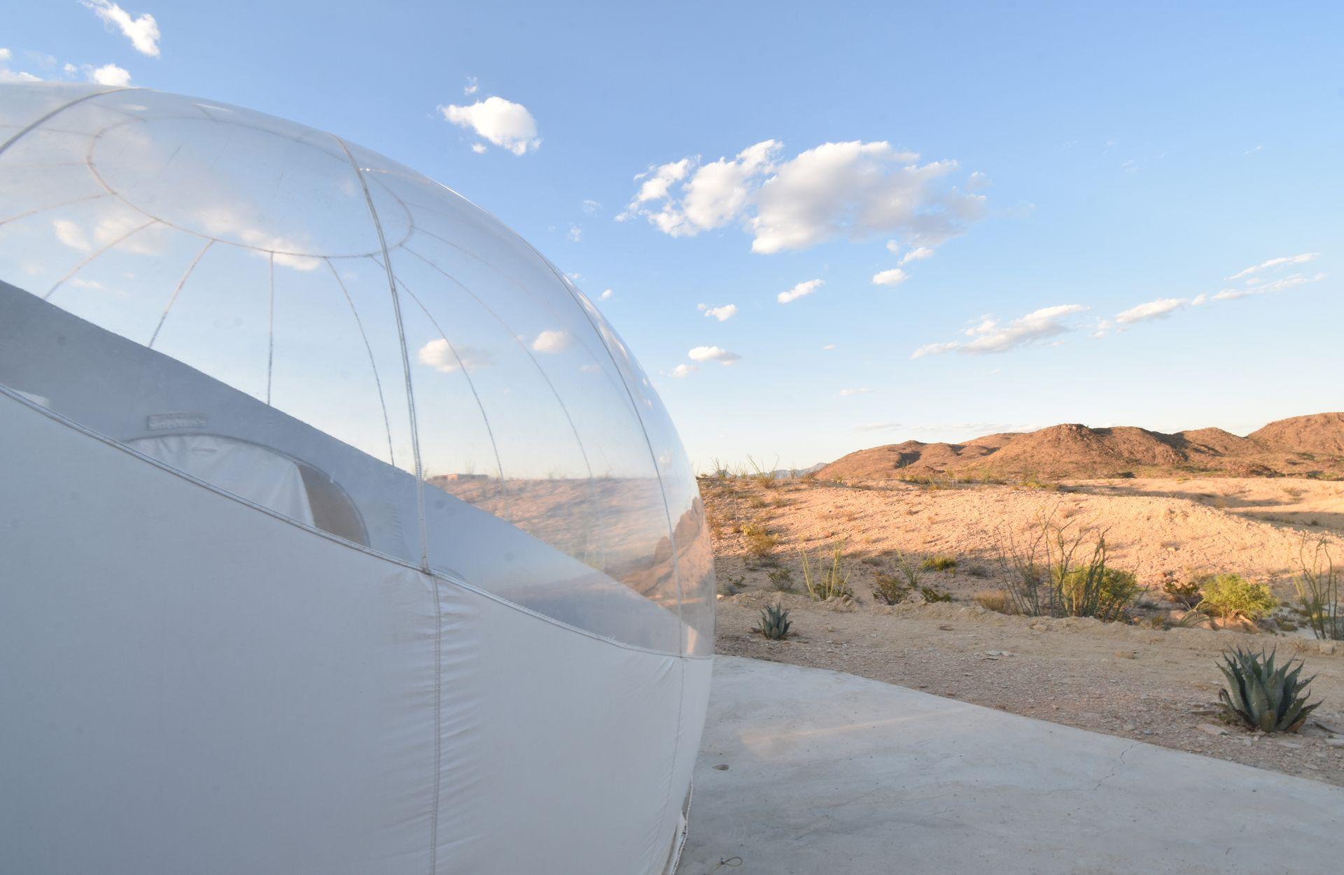 The side of a clear bubble and views looking out at the desert.