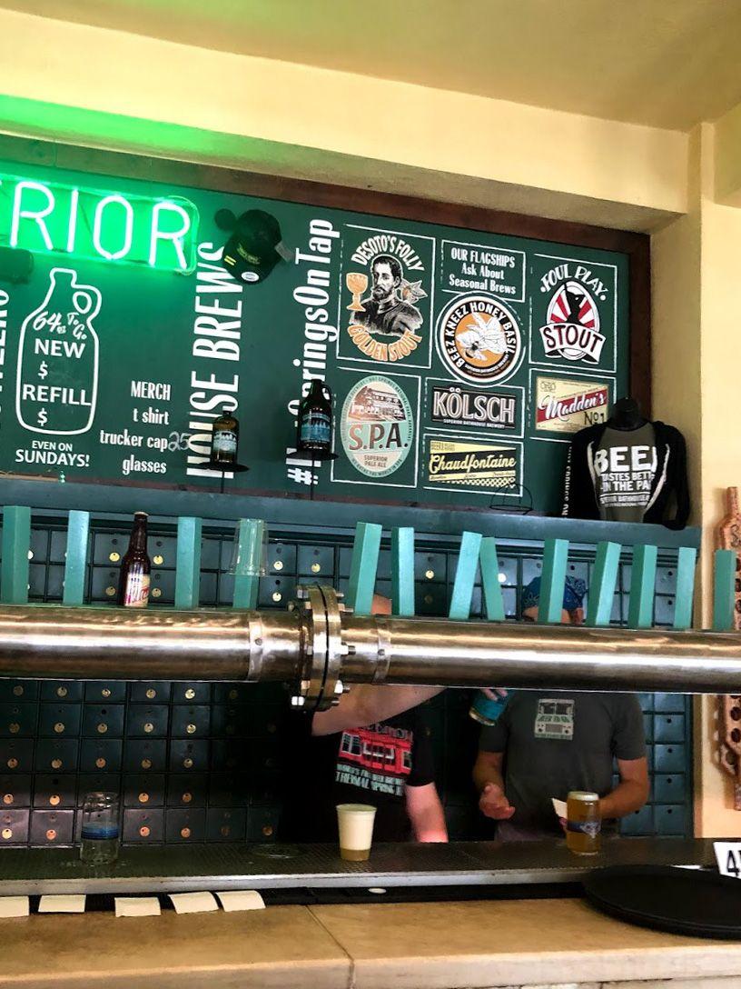 The bar at Superior Bathhouse Brewery, which looks like a locker area. The taps are connected to a green pipe.