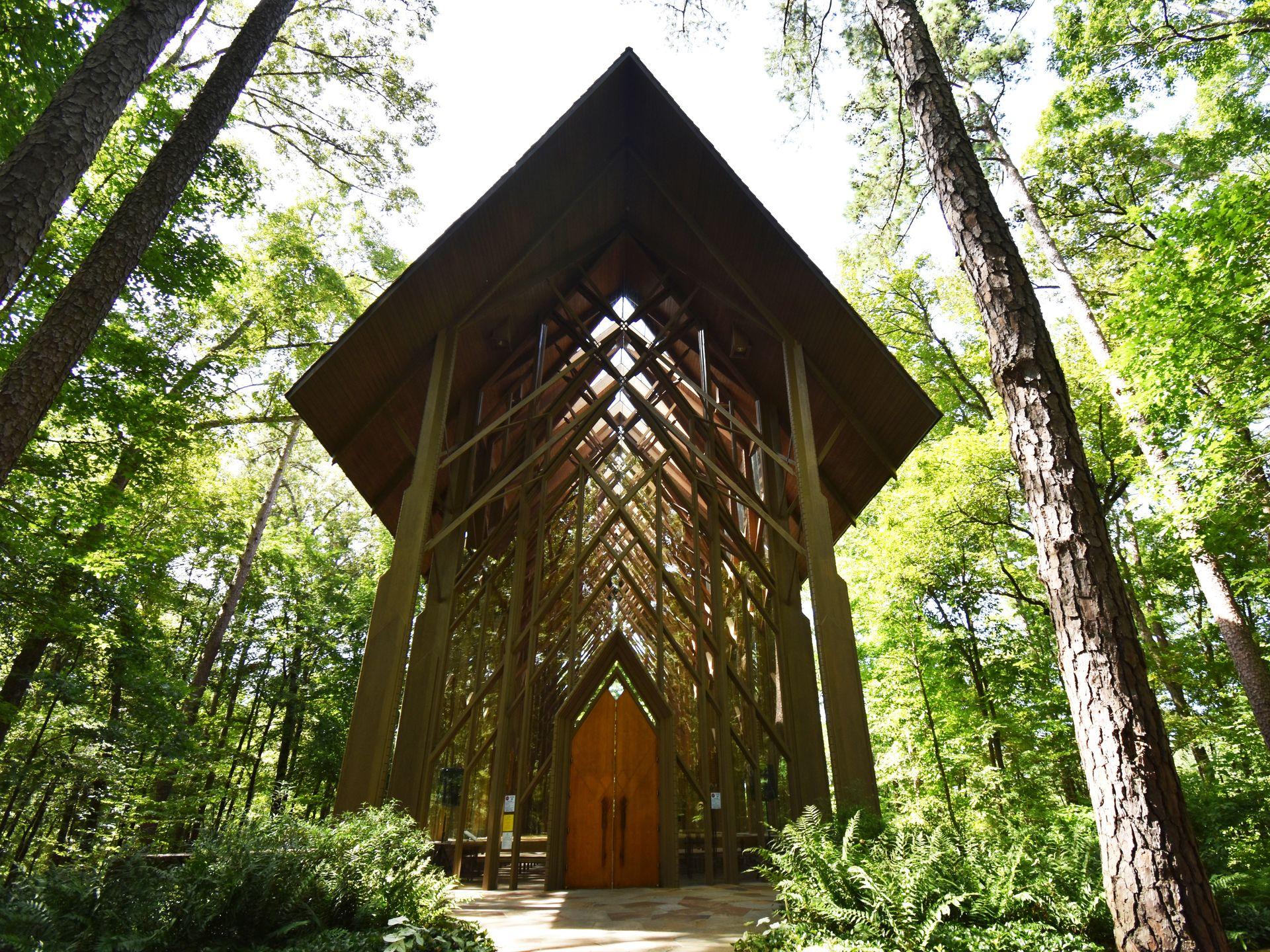 A glass chapel surrounded by tall greens in Garvan Woodland Gardens.