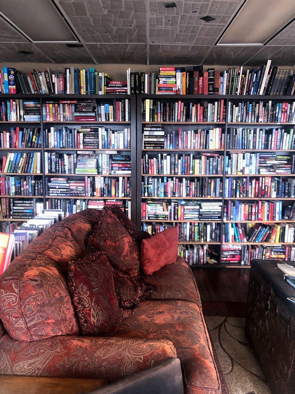 A couch in front of a wall of books at The Full Cup.