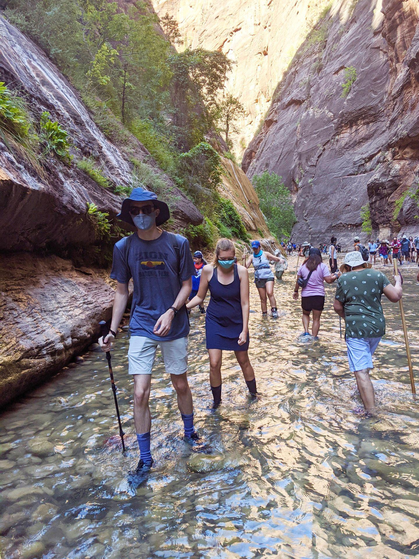 A view of how crowded The Narrows was in summer 2020. There are many people in the water of the canyon.