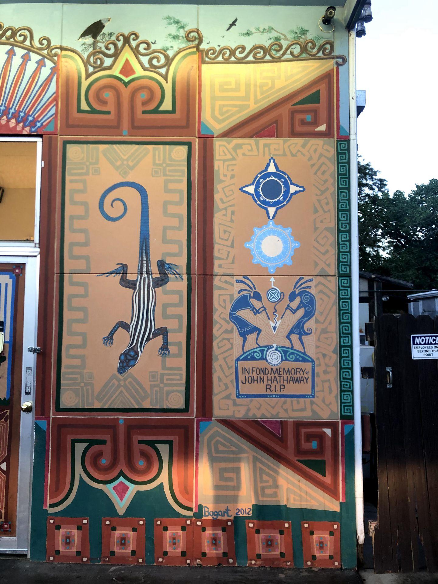 A mural on the outside of Whiptail with a lizard and abstract shapes.